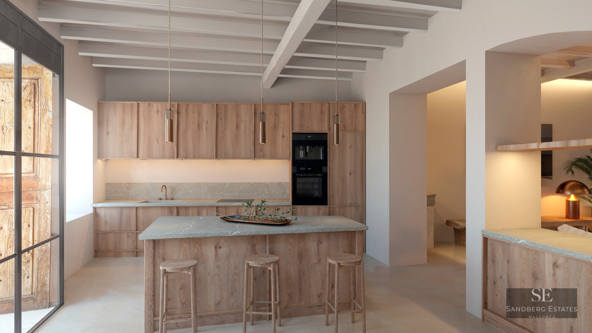 Luxury kitchen featuring light wood cabinets, stone island with stools, and exposed ceiling beams.