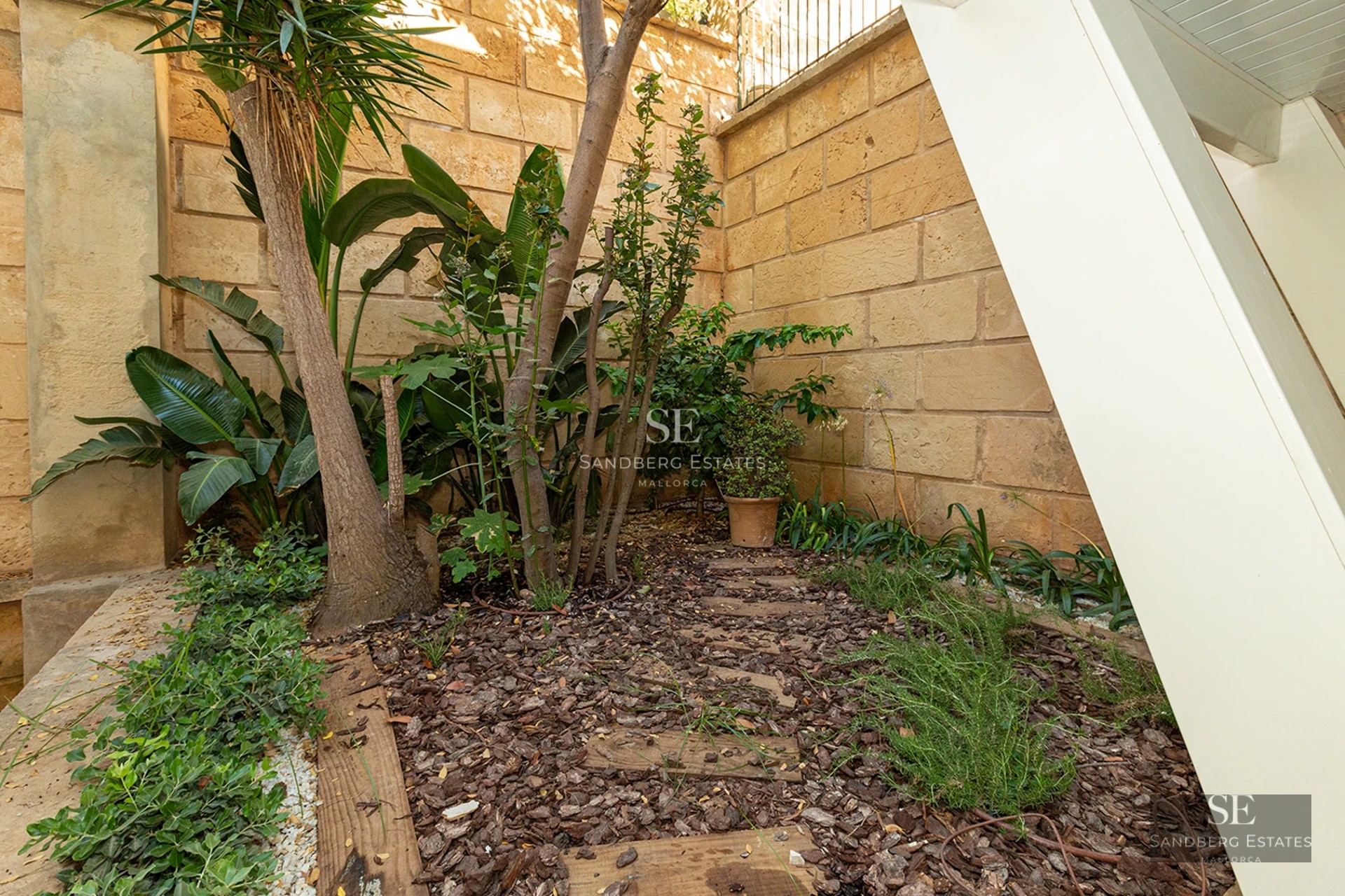 Spacious living room featuring a fireplace, large windows, natural light, wood flooring, and designer furniture. Garden and pool views.