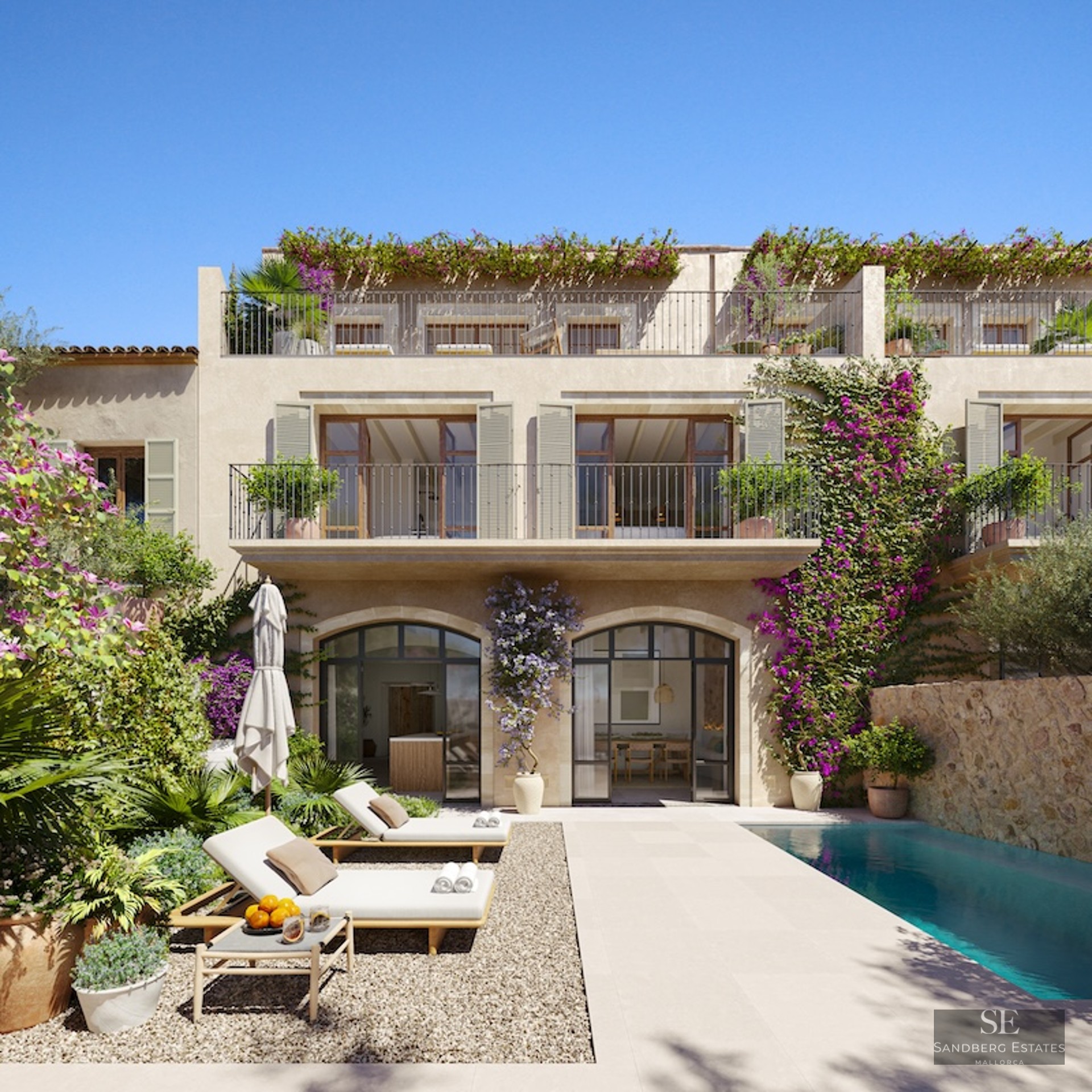 Luxury villa featuring a turquoise pool, sun loungers, stone arches, and vibrant bougainvillea under a clear blue sky.