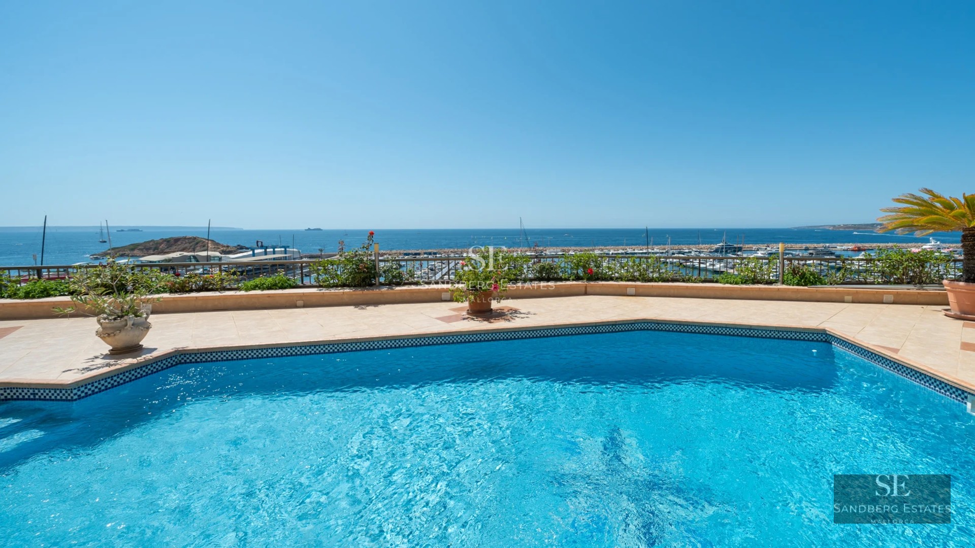 Terrace with infinity pool, panoramic sea views, modern furniture, and elegant design details. Glass railing.