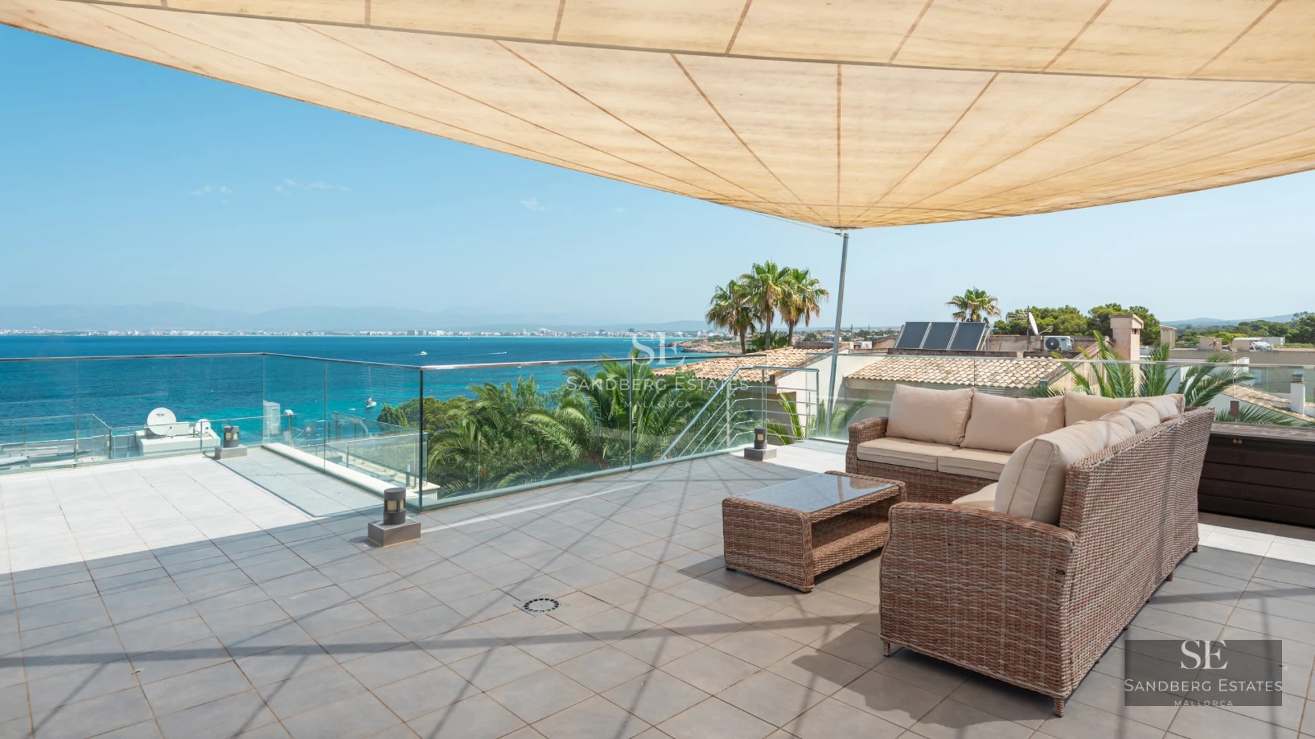 Expansive terrace with infinity pool, sun loungers and panoramic sea views. Modern design with elegant furniture and lush greenery.