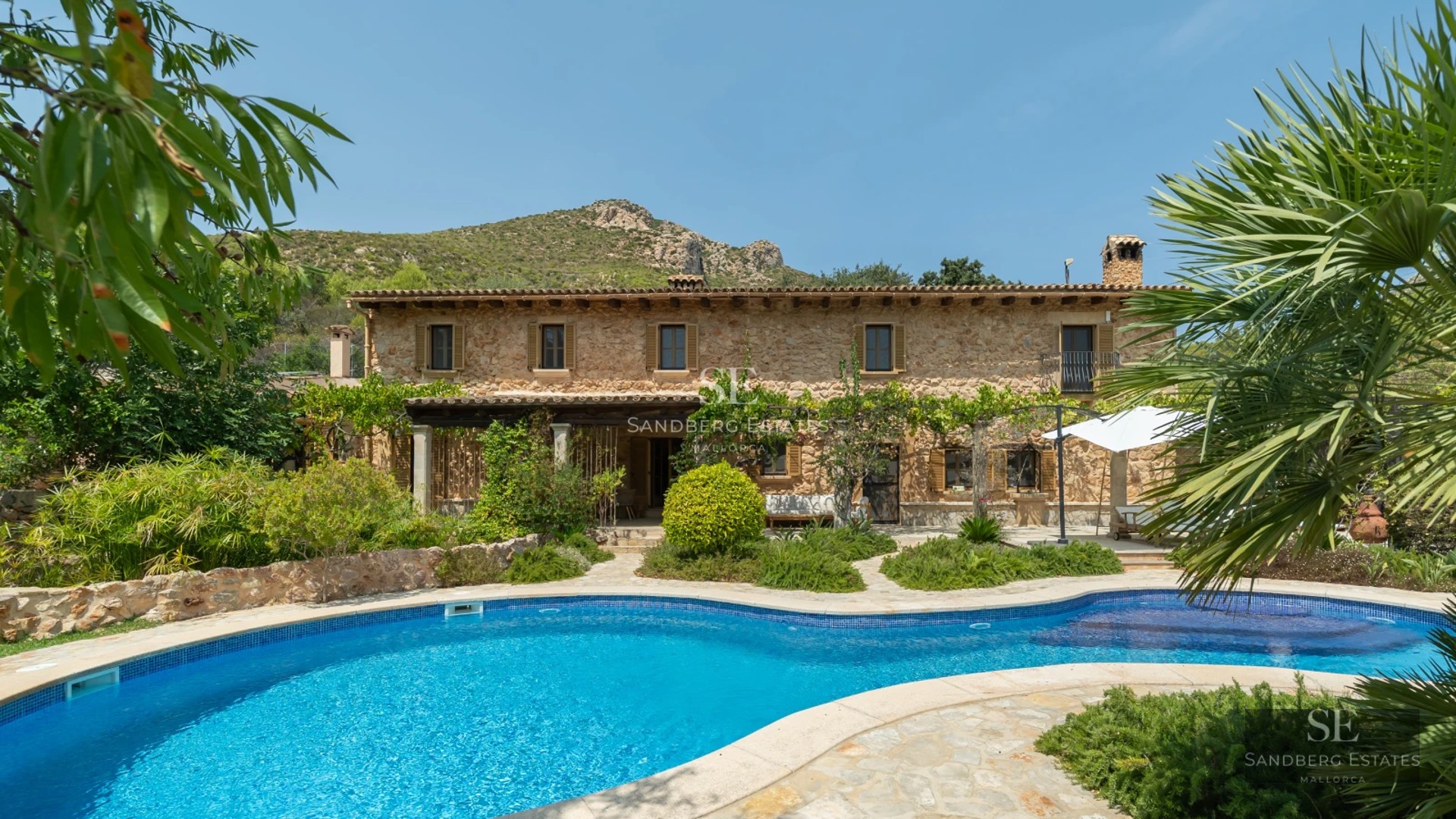 Panoramic view of a modern villa featuring an infinity pool, expansive terraces, and minimalist design. Lush gardens and elegant architecture.