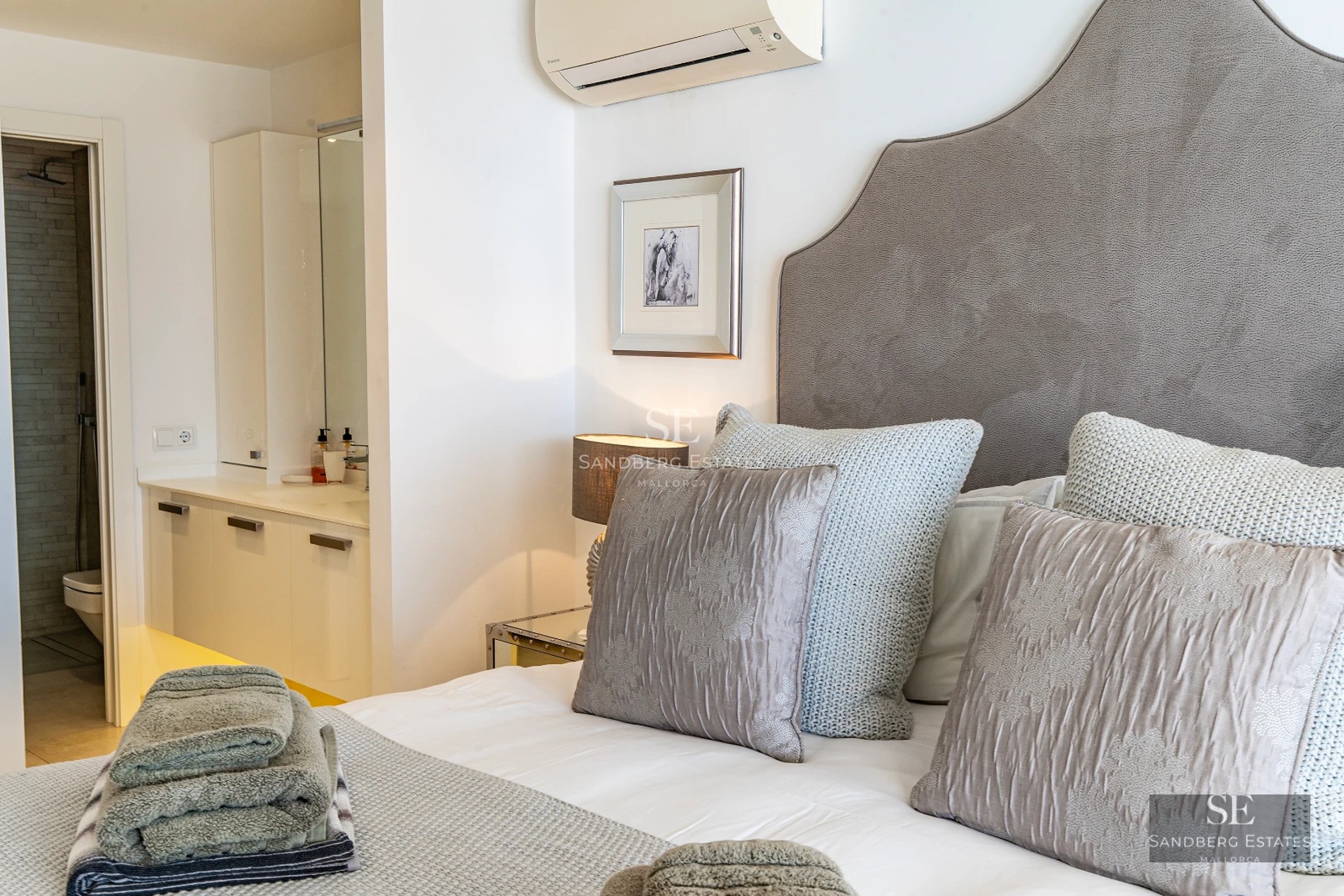 Spacious living room with panoramic windows, light wood flooring, modern design, gray sofas, and access to a terrace with a view. Elegance and comfort.