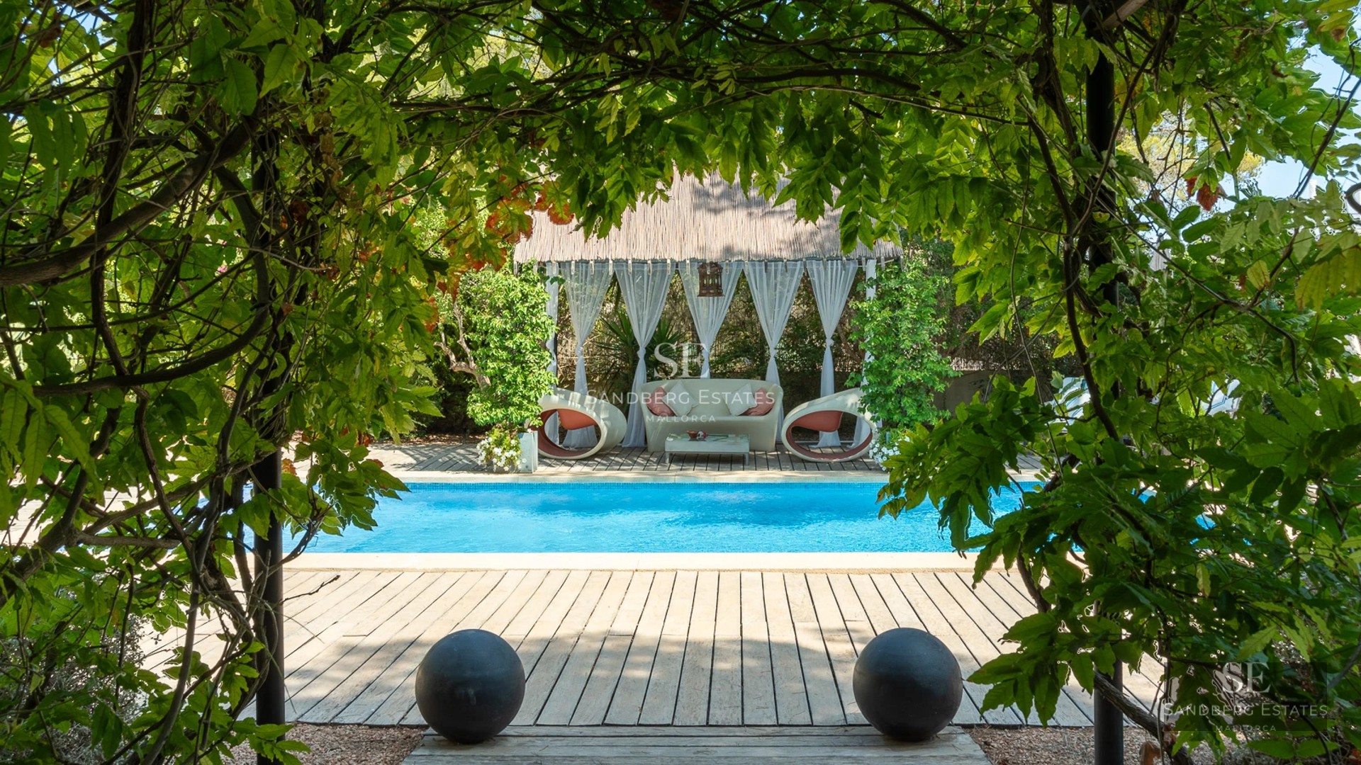 Exterior view of a modern villa with a pool, garden, and terraces. Minimalist architecture with large windows.