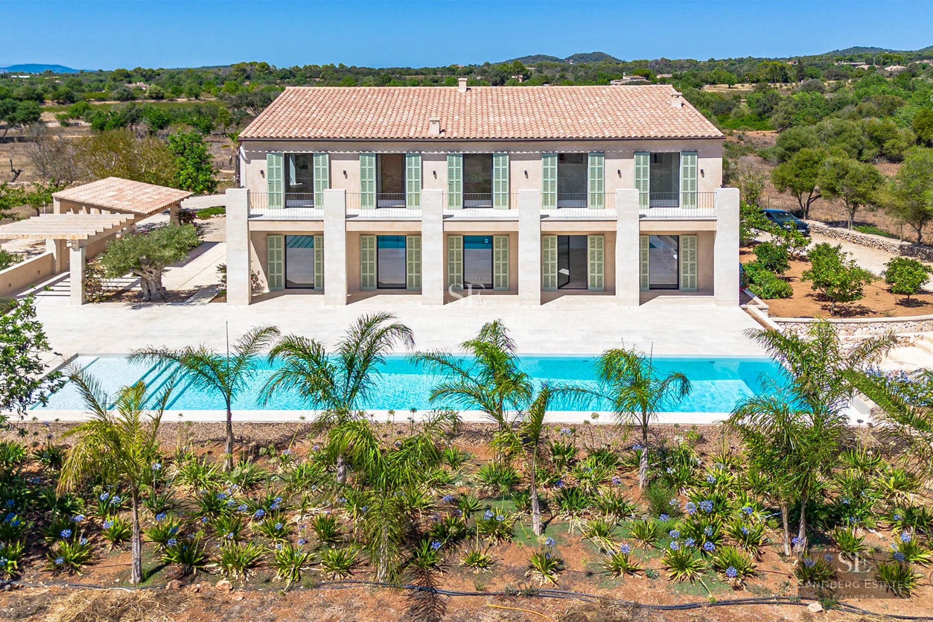 Exterior view of modern villa with infinity pool, large garden, and minimalist architecture. Ideal for investment.