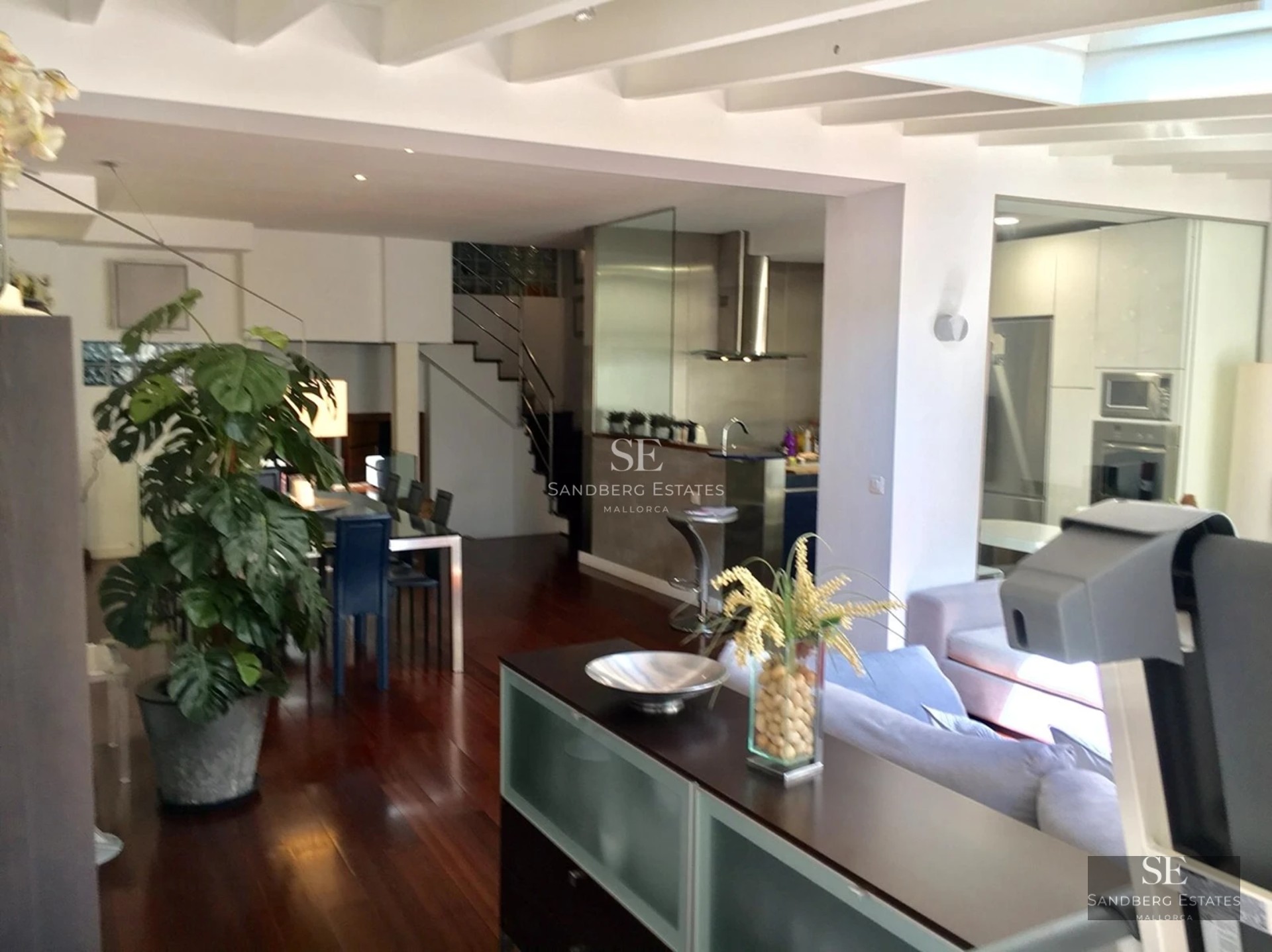 View of a modern villa with an infinity pool, sun loungers and lush vegetation. Clean and elegant architectural design.