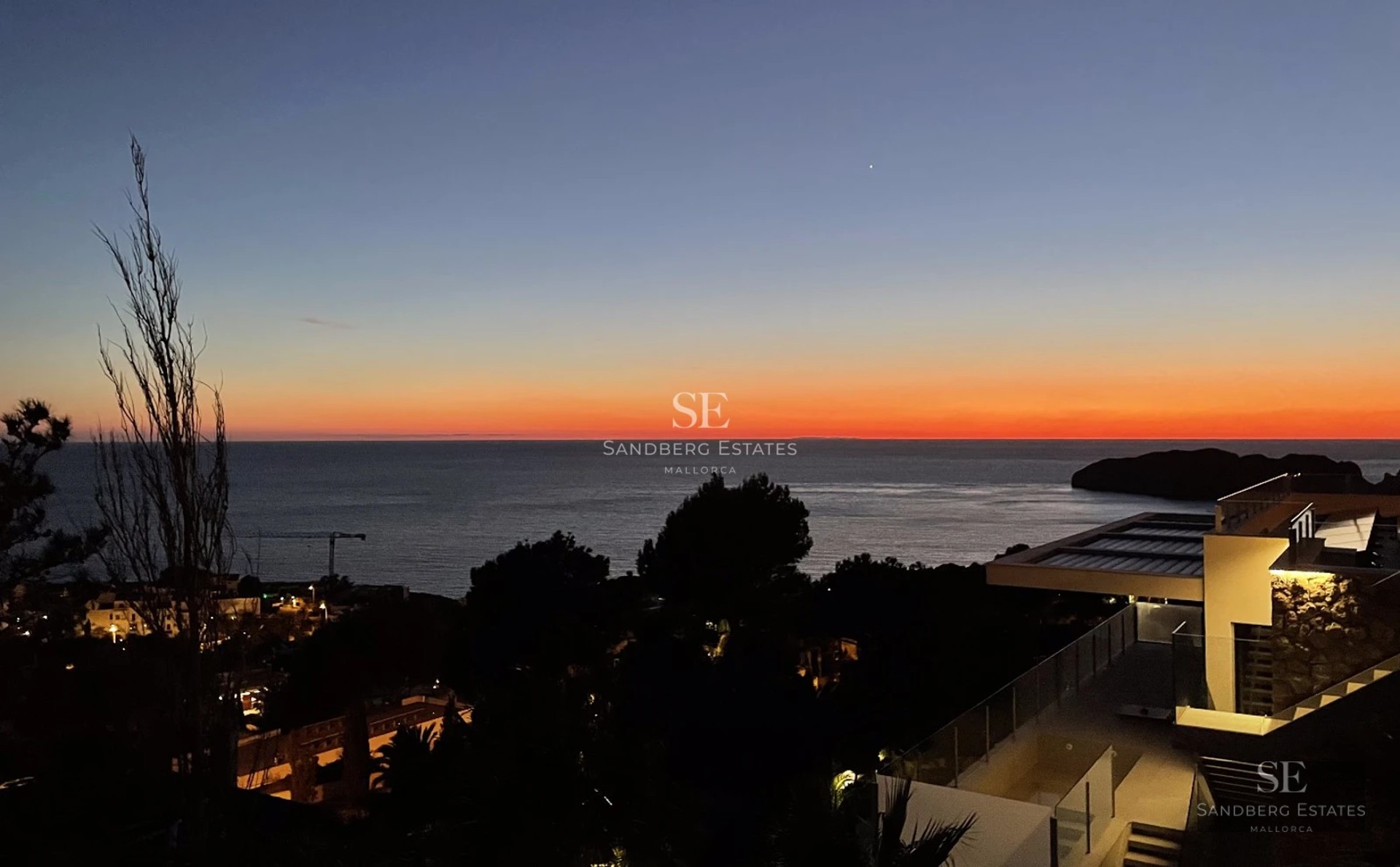 Expansive terrace with infinity pool and ocean view. Modern design, lounge chairs, and lush vegetation.