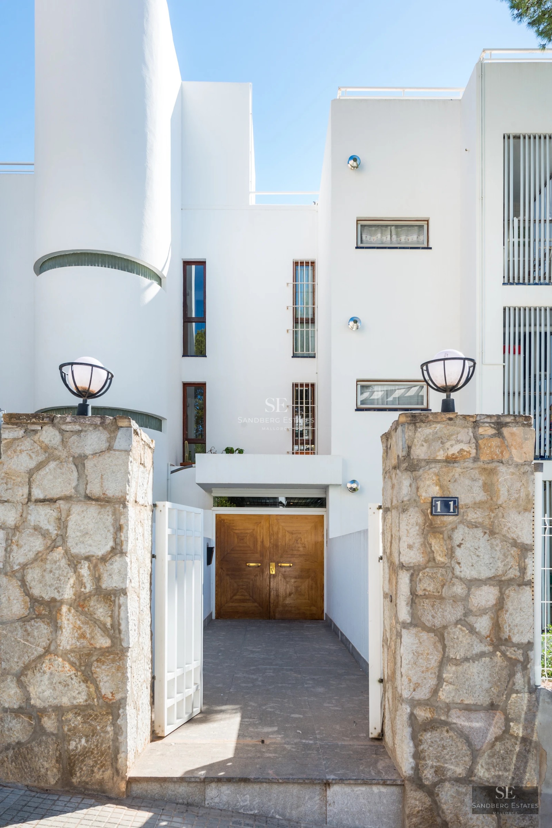 Exterior of a modern villa featuring a swimming pool, manicured garden, and expansive windows. Minimalist architectural design.