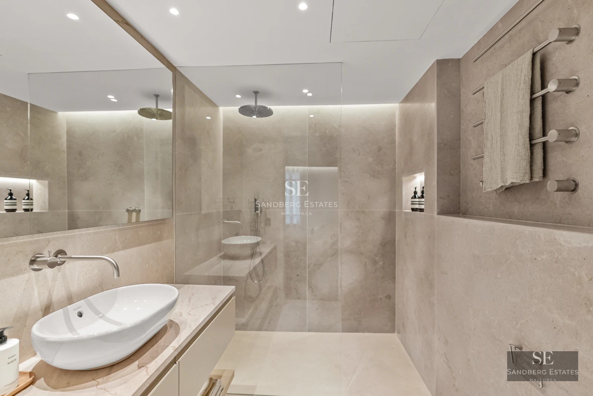 Exterior view of a modern villa featuring an infinity pool, spacious garden, and expansive windows reflecting the sky. Minimalist architecture.