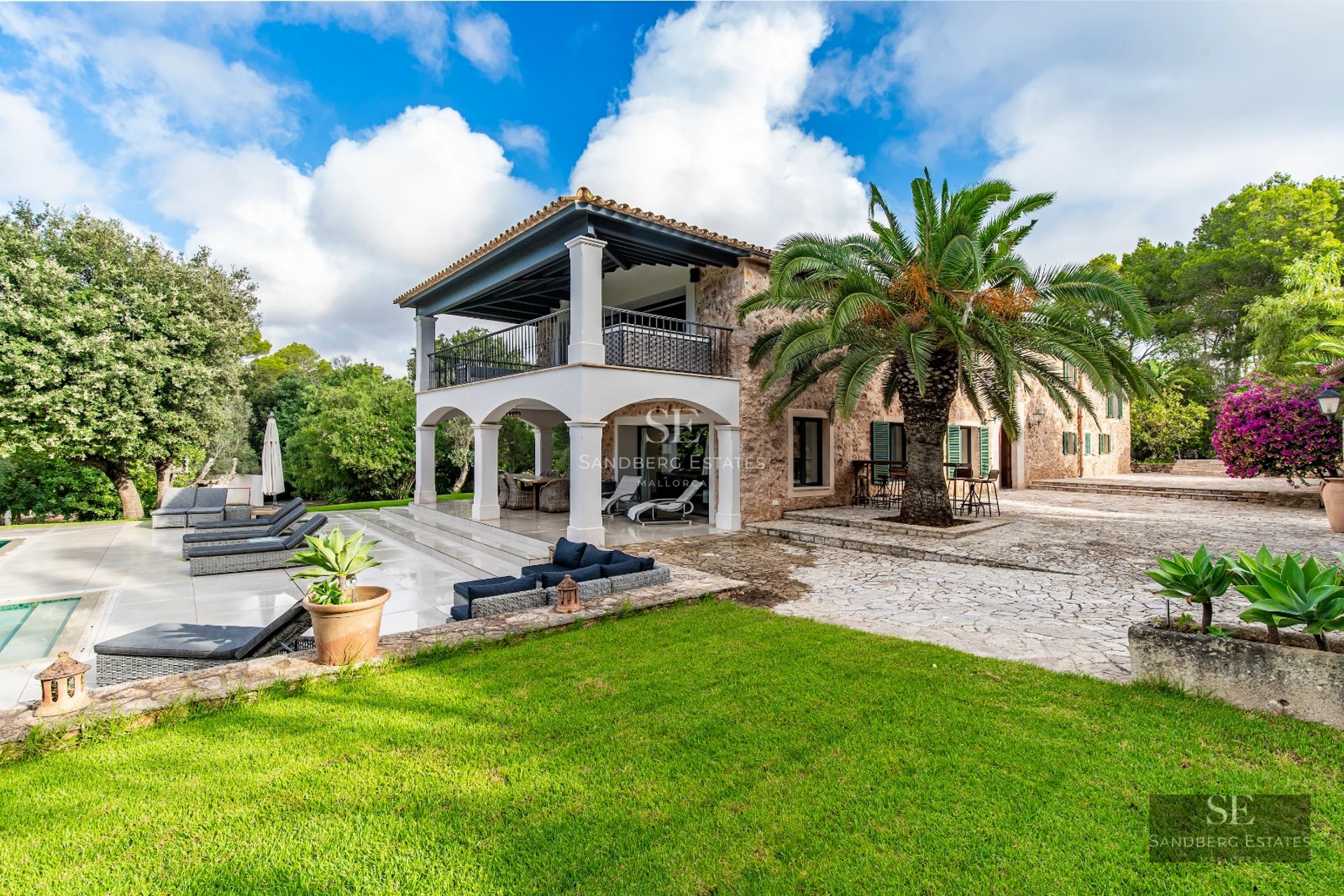 View of a modern infinity pool, surrounded by lush vegetation with a minimalist design house in the background.