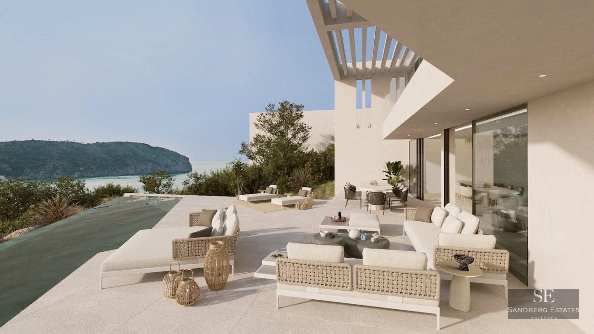 Modern white terrace with infinity pool, stylish outdoor furniture, and panoramic views of a Mediterranean bay.