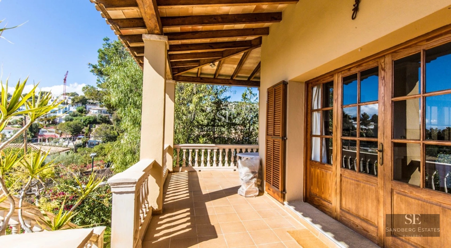 Modern living room with large windows, pool reflecting light. Minimalist interior. Gray sofa. Abundant natural lighting.