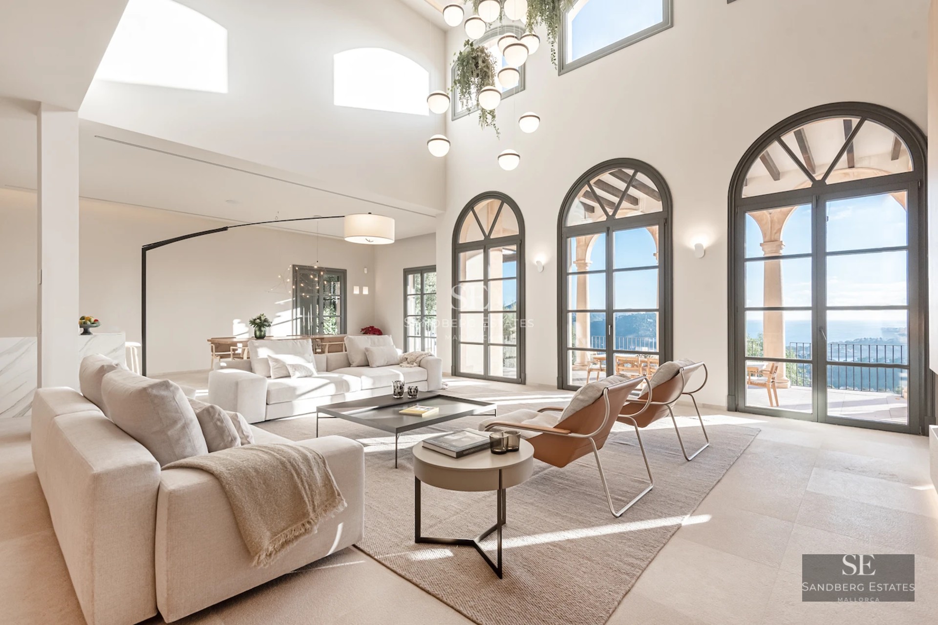 Spacious balcony with sea view. Glass railing, wooden floor, and modern outdoor furniture. Minimalist design with natural light.