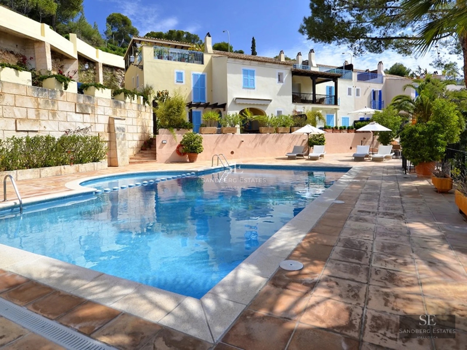 Spacious terrace with a view. Modern and stylish furniture, wood flooring, ambient lighting, and lush greenery.