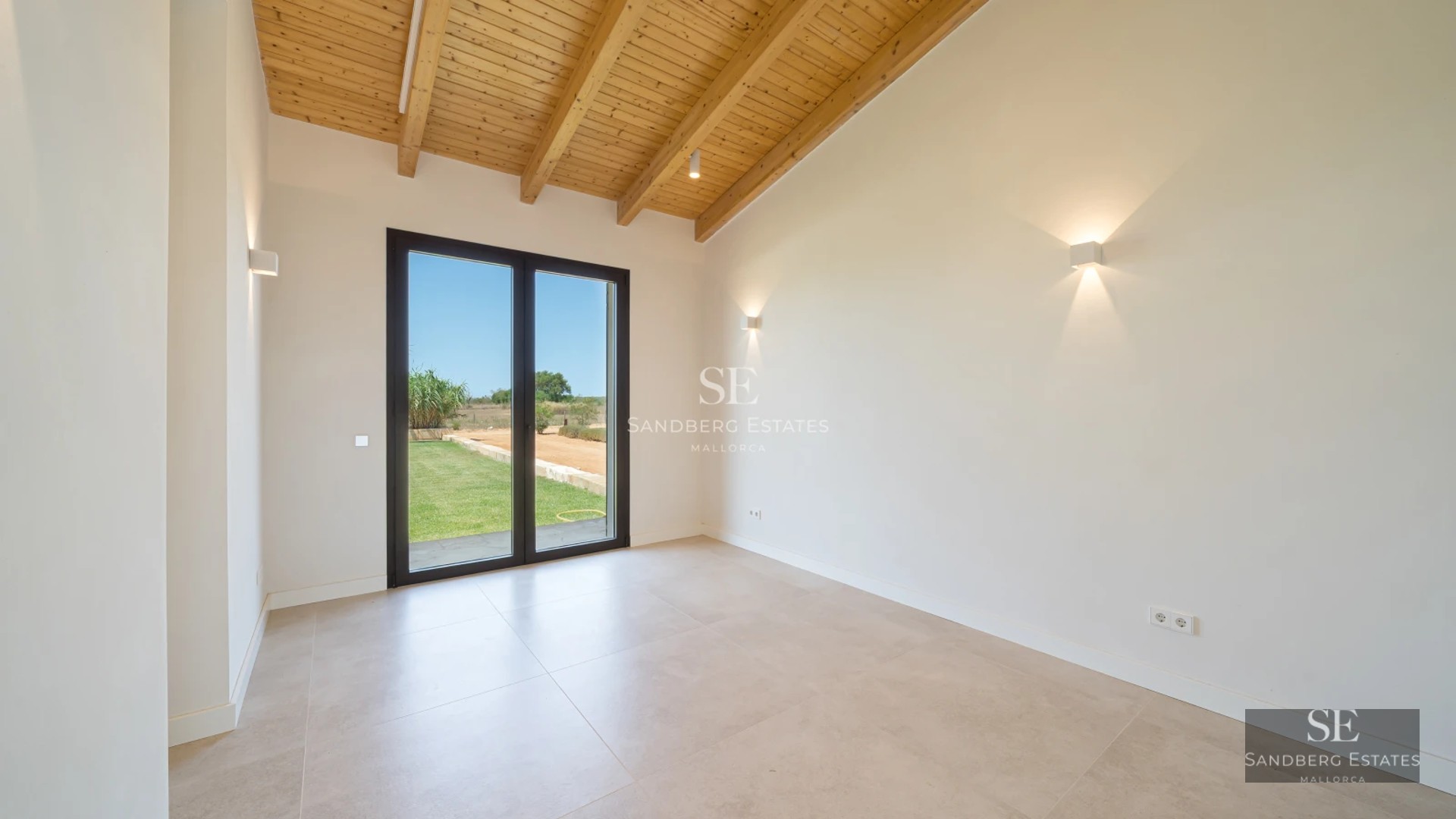 View of modern infinity pool, sun loungers, and minimalist architecture. Large windows reflect sunlight.