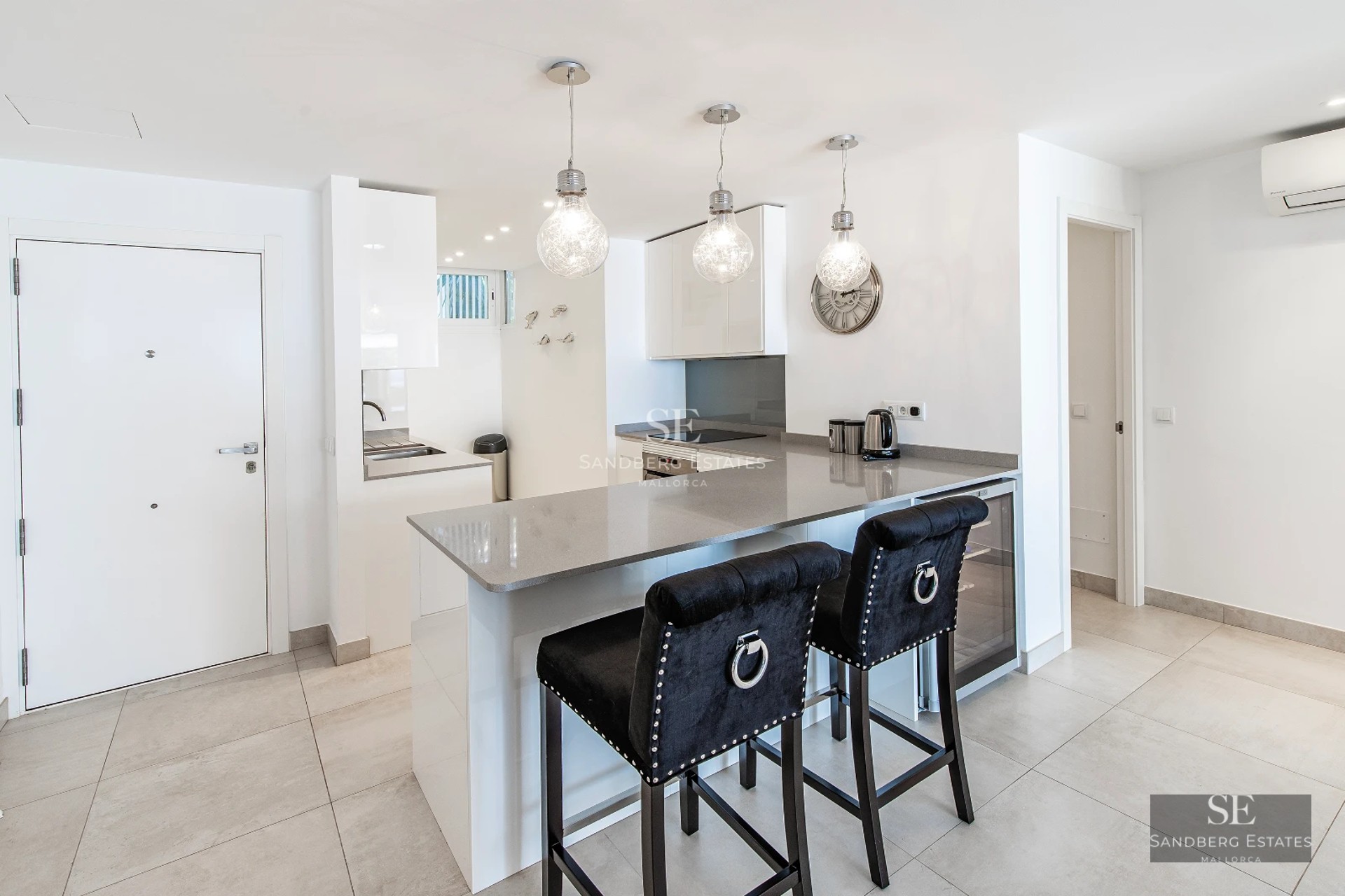 Spacious, bright living room featuring large windows, light wood floors, and modern furniture. Panoramic outdoor views.