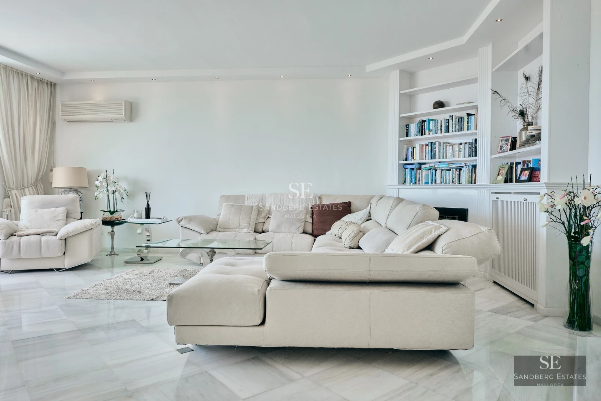 Bright interior with modern design, light wood floors, and large windows. Minimalist decor in neutral tones.