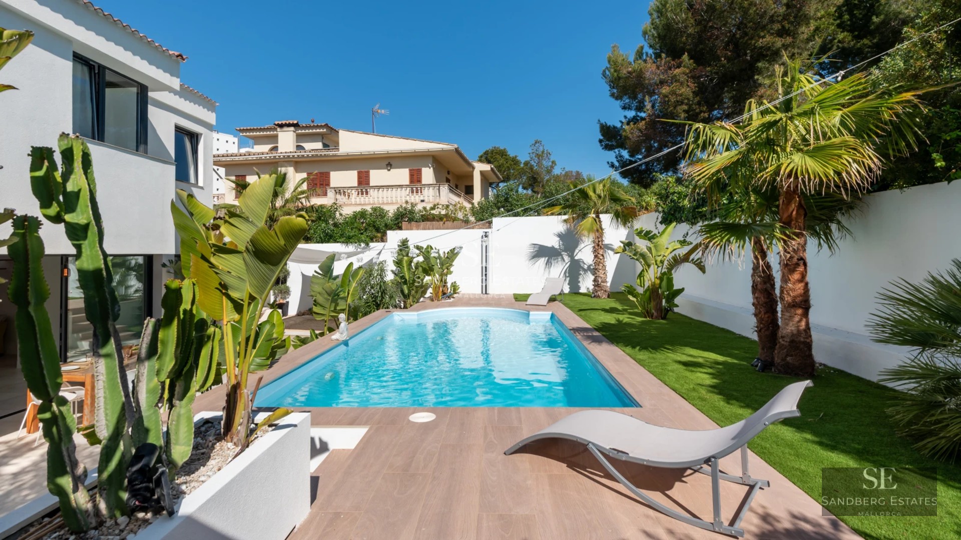 Spacious living room with picture windows, modern fireplace, and balcony access offering stunning views. Minimalist decor in neutral tones.