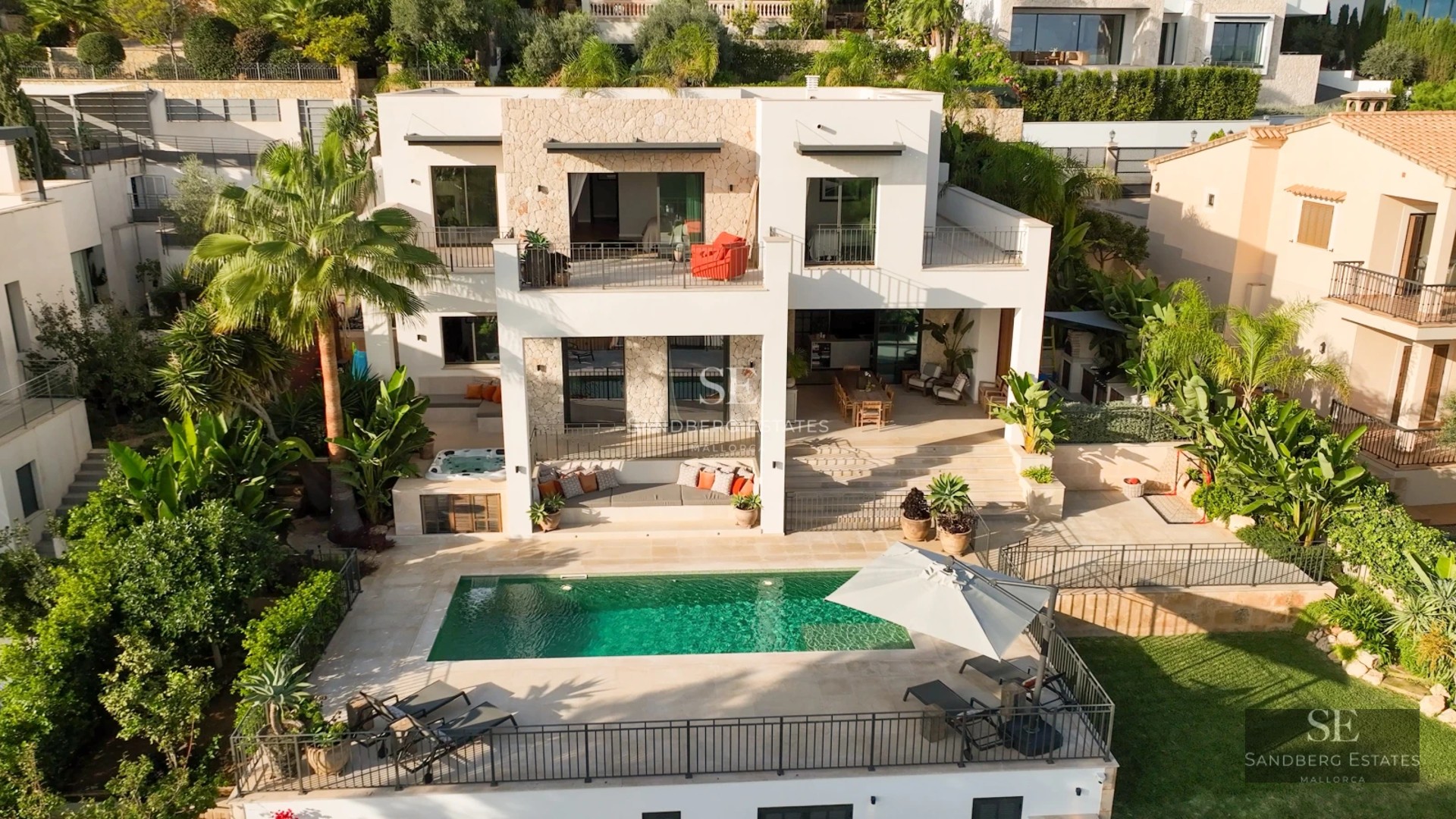 Balcon moderne avec rambarde en verre, vue sur mer et mobilier design. Éclairage chaleureux et finitions luxueuses.