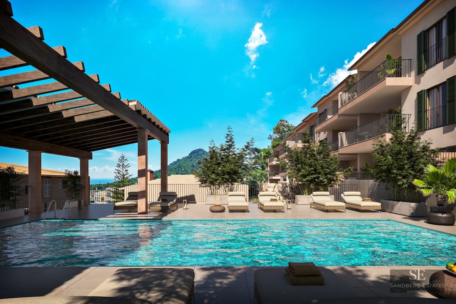 Turquoise swimming pool with sun loungers under a wooden pergola overlooking mountains and the sea under a blue sky.