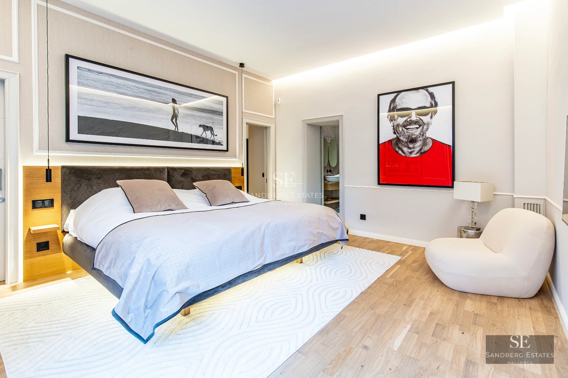 Spacious living room with balcony and ocean view. Light wood floors, white walls and modern furniture in neutral tones.