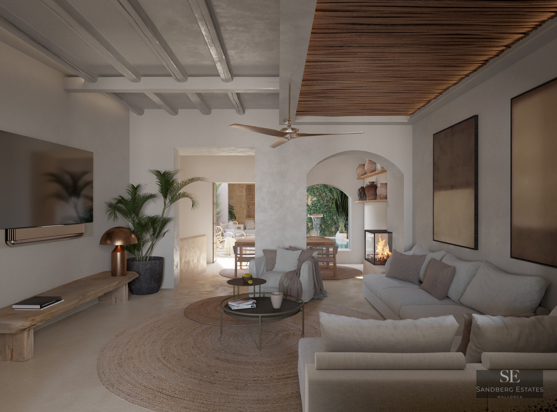 Luxurious living room featuring beige sofas, beamed ceilings, a modern fireplace, and views to a courtyard pool through an arch.