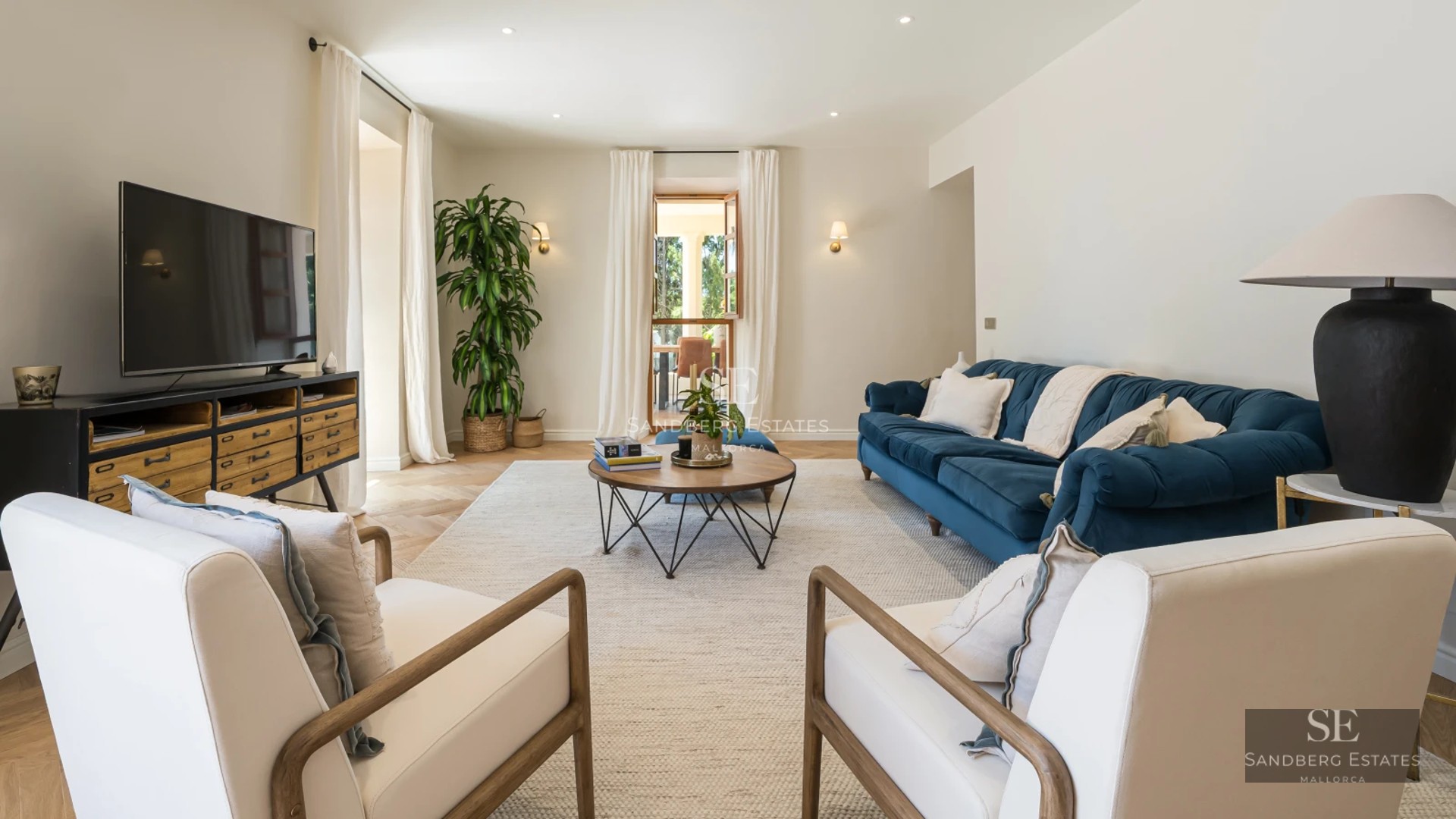 View of an elegant pool with sun loungers and umbrellas. Modern architecture with large windows and lush vegetation surrounding it.
