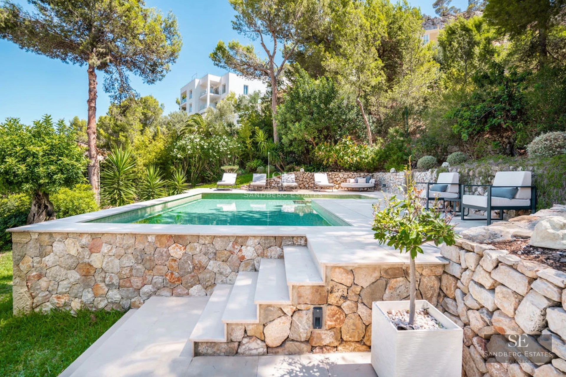 Exterior of modern villa with infinity pool, lush garden, and large windows. Minimalist design and panoramic views.