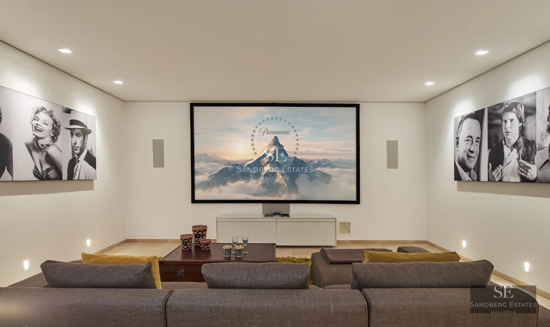 Spacious living room with fireplace, panoramic windows, and outdoor views. Modern design with wood floors and elegant furniture. Abundant natural light.