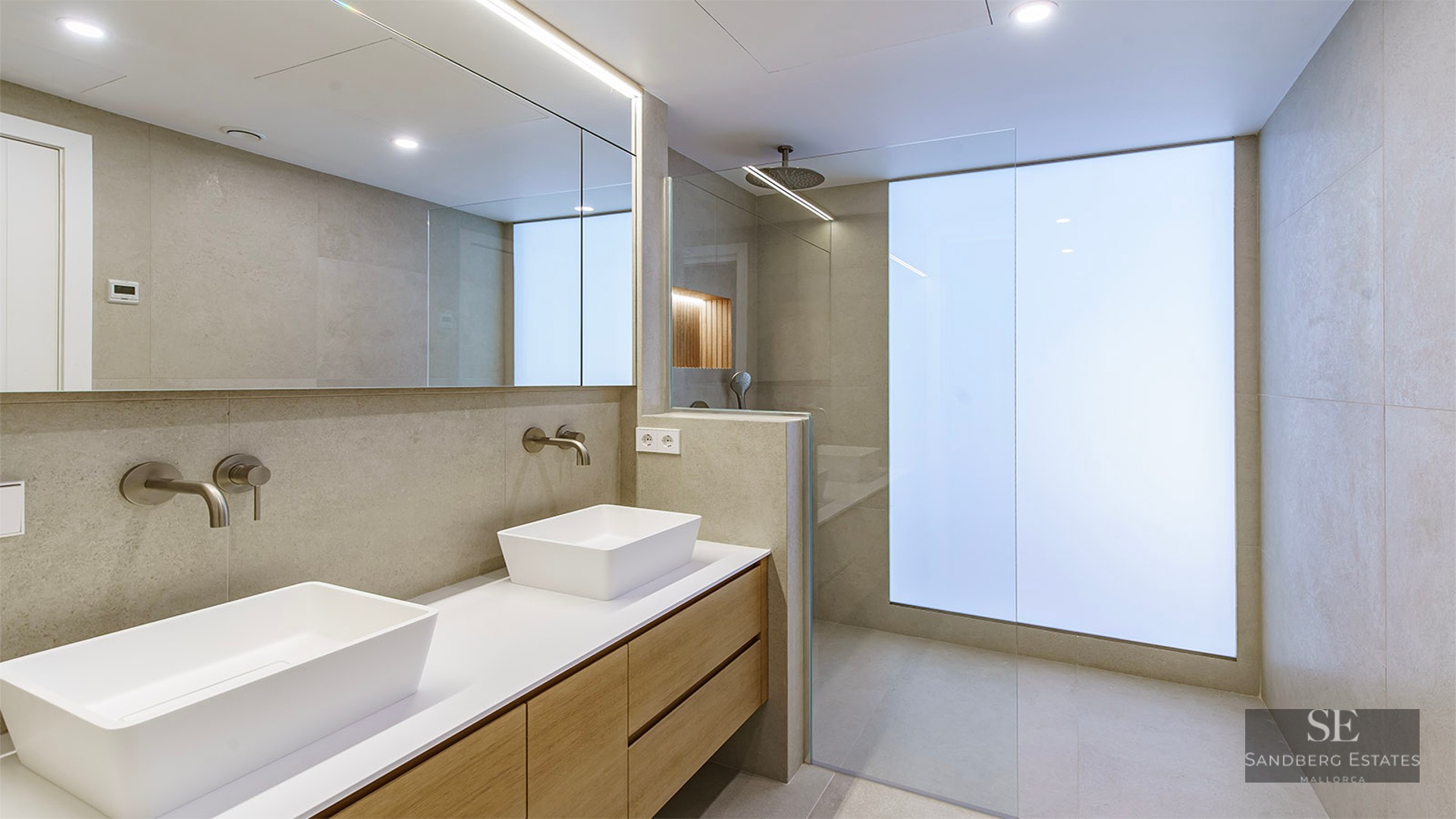 Salle de bain moderne avec double vasque en bois, lavabos blancs et douche à l'italienne avec verre dépoli.