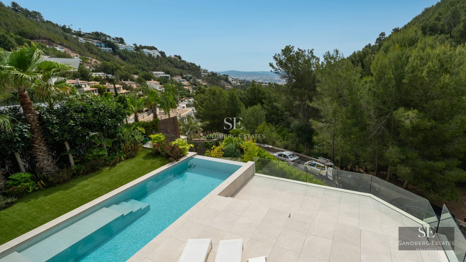 Expansive terrace featuring an infinity pool, sun loungers, and panoramic views. Modern design with clean lines and high-quality materials.