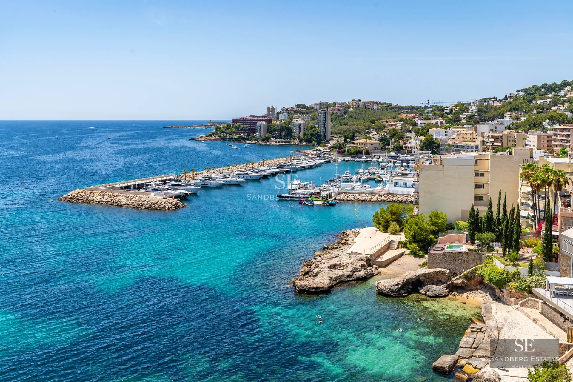 Spacious living room with panoramic windows, sea views, modern decor, and terrace access. Designer furniture.