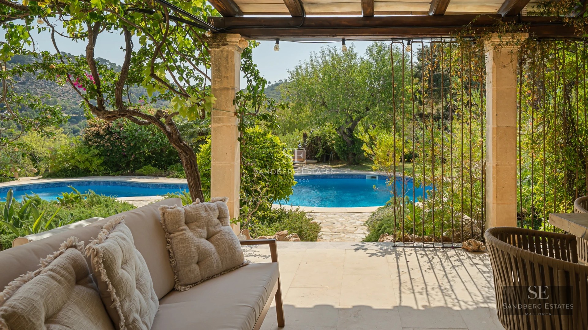 Exterior view of a modern villa featuring an infinity pool, lush gardens, and spacious terraces. Contemporary architectural design.