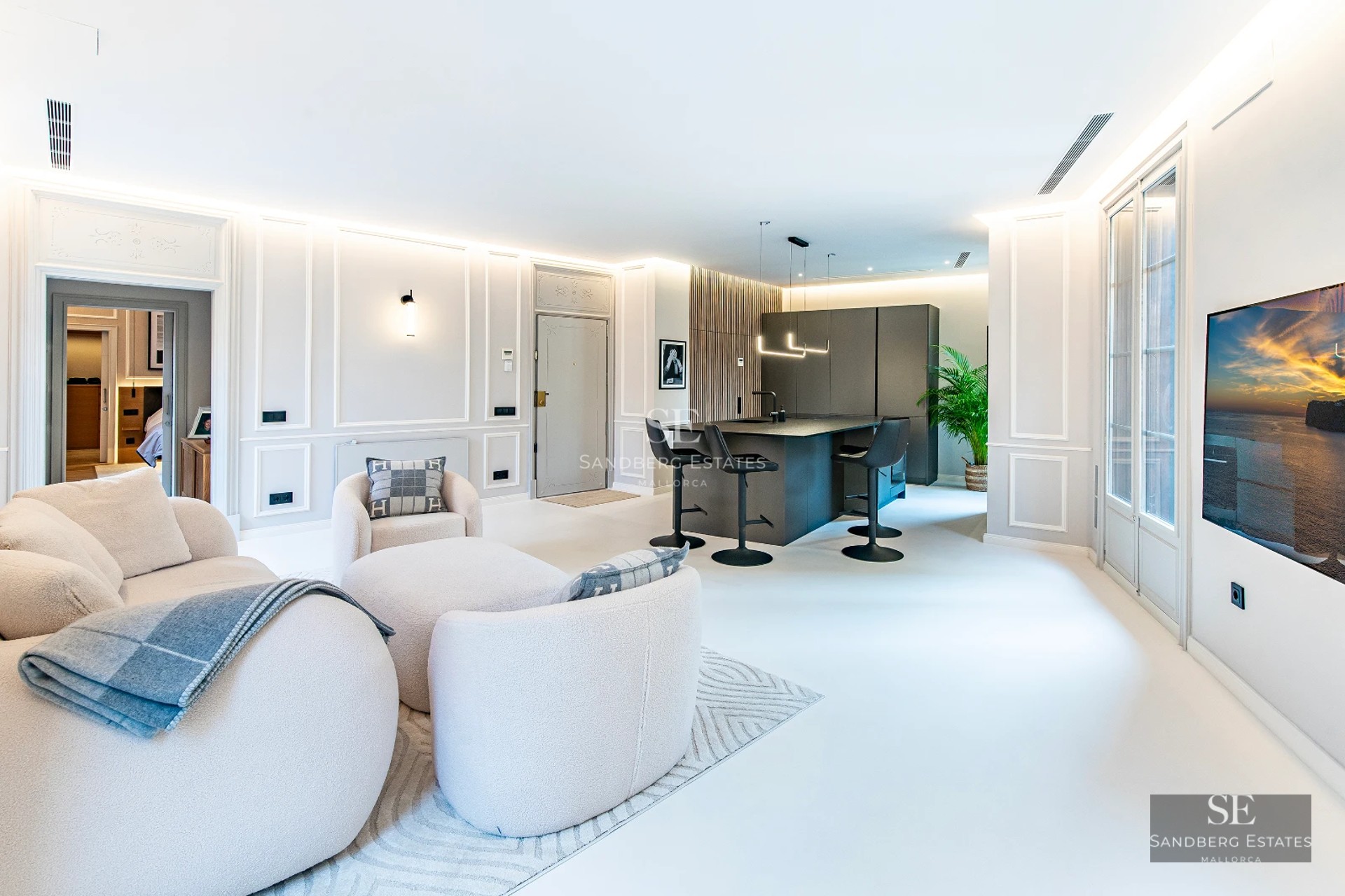 View of the infinity pool with glass edge, surrounded by cream-colored tiles. Modern, minimalist architecture with ocean views.