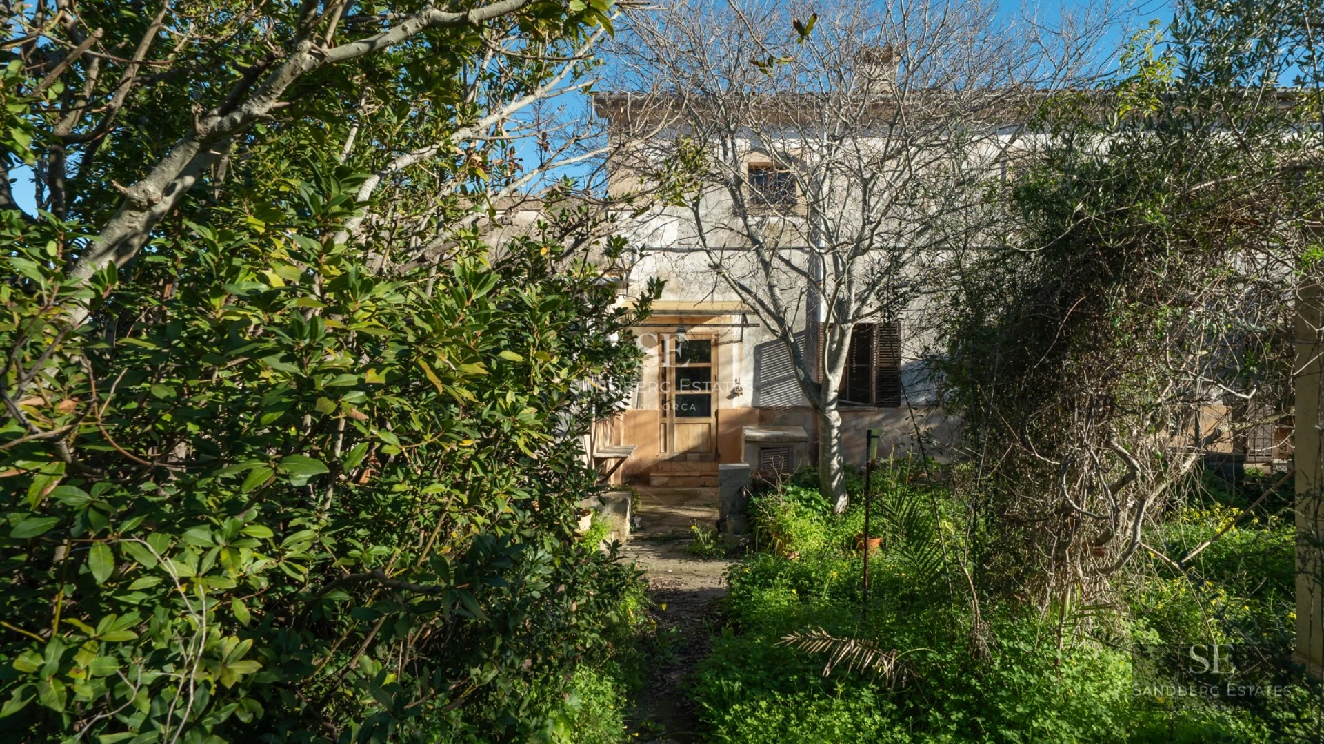 Exterior view of a modern villa with a pool, manicured garden, and large windows reflecting light. Minimalist and elegant design.