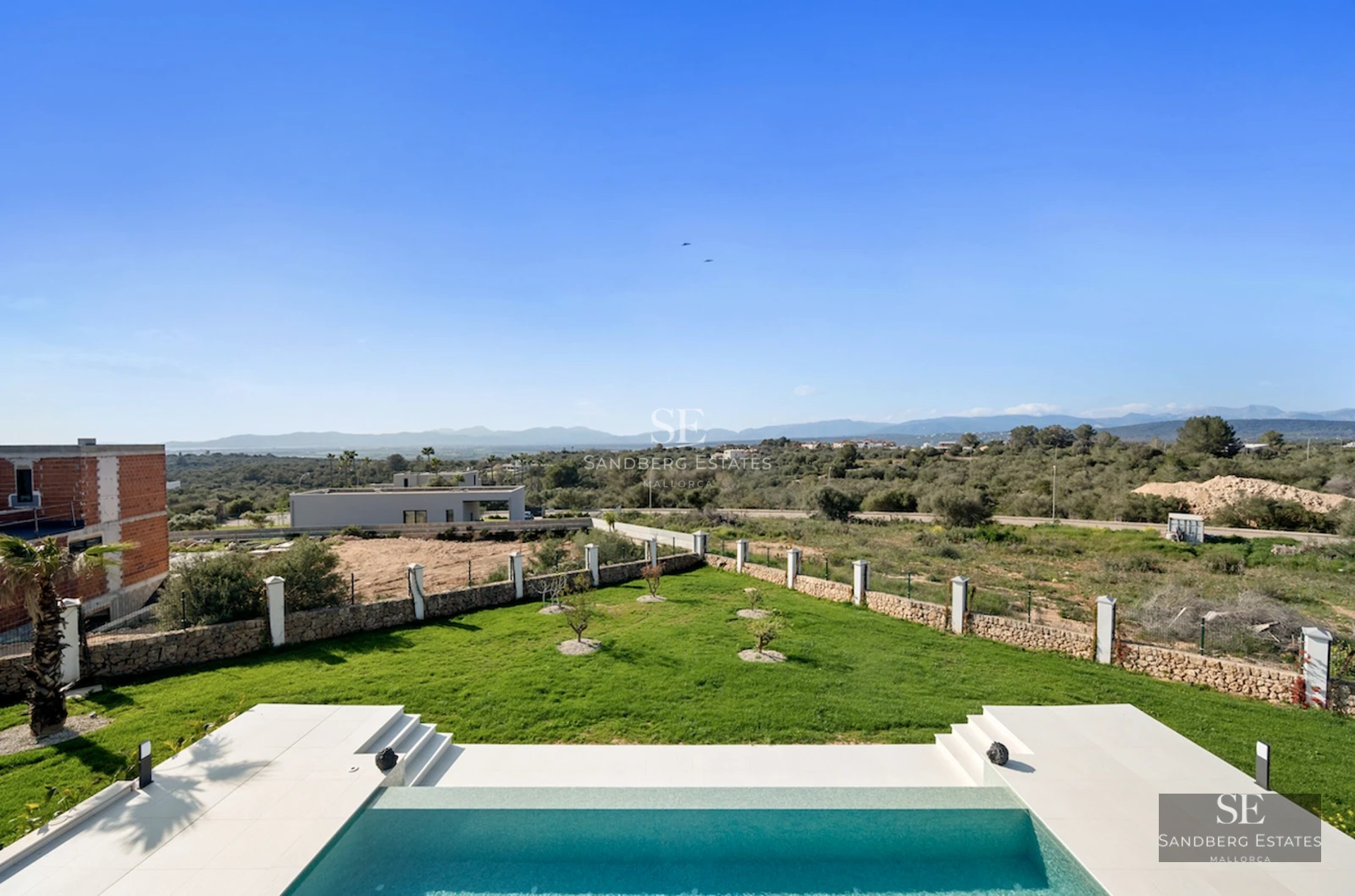 Exterior view of a modern villa with infinity pool, expansive terraces, and lush landscaping. Minimalist and elegant architecture.