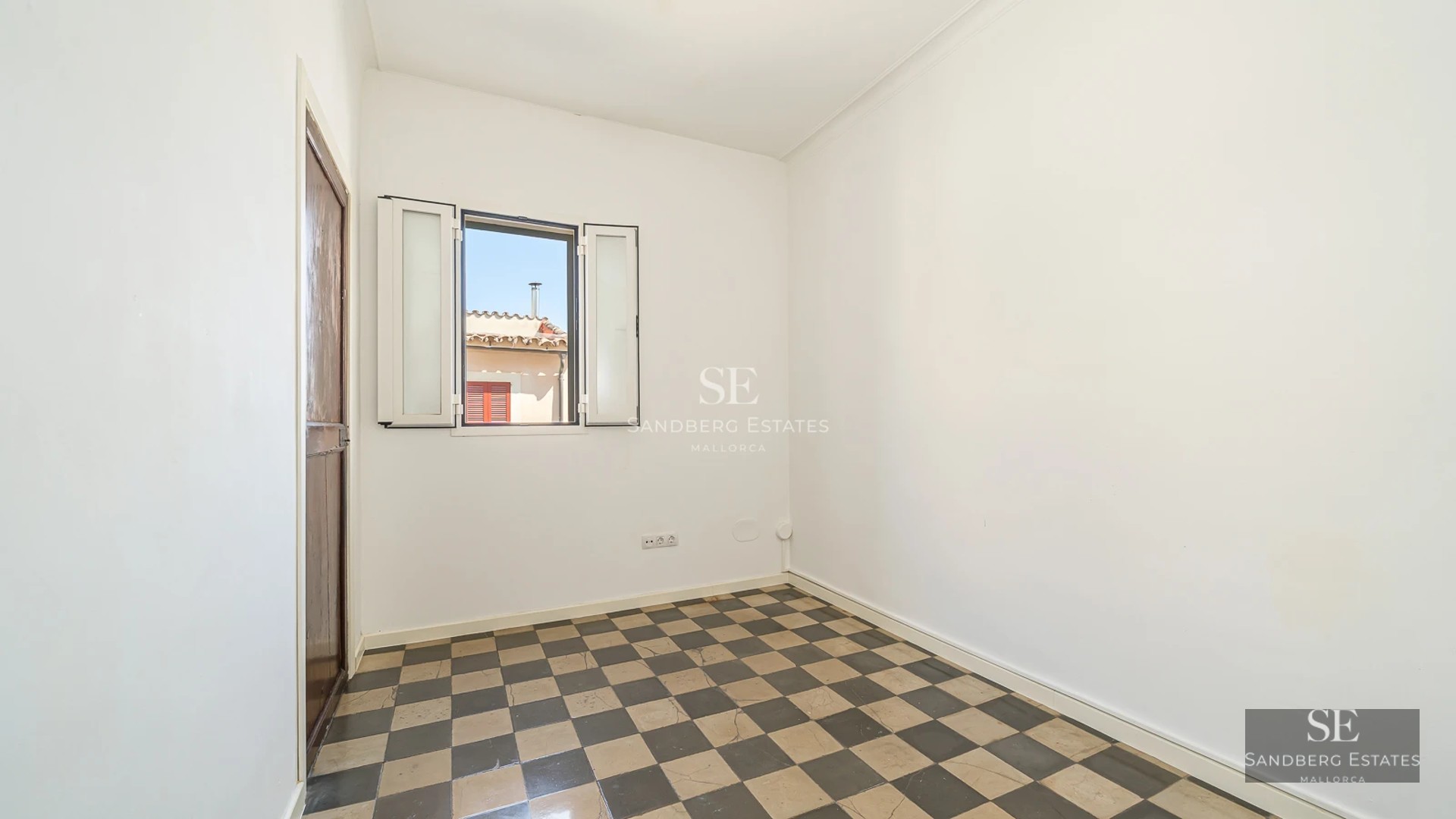 Panoramic view of furnished balcony overlooking the sea with modern outdoor furniture including table, chairs, and awning.