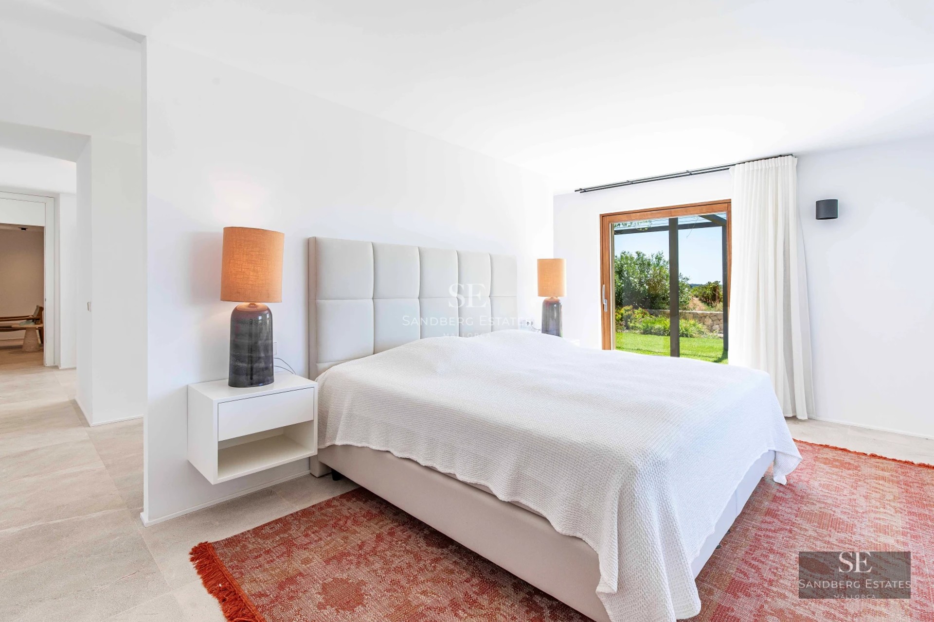 Spacious living room with sea views through panoramic windows. Modern design, light wood floors, neutral sofas, and minimalist decor. Natural lighting.