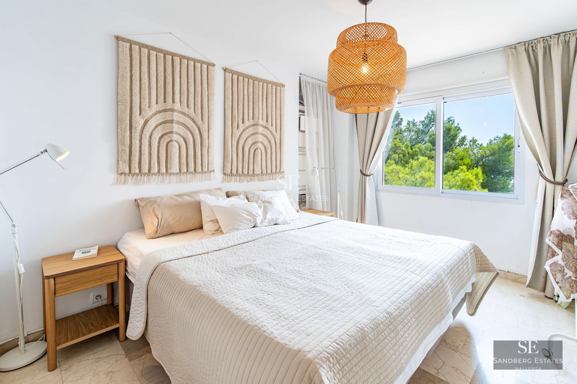 Exterior of a modern villa featuring an infinity pool, lush garden, and minimalist facade with light stone and large glass windows.