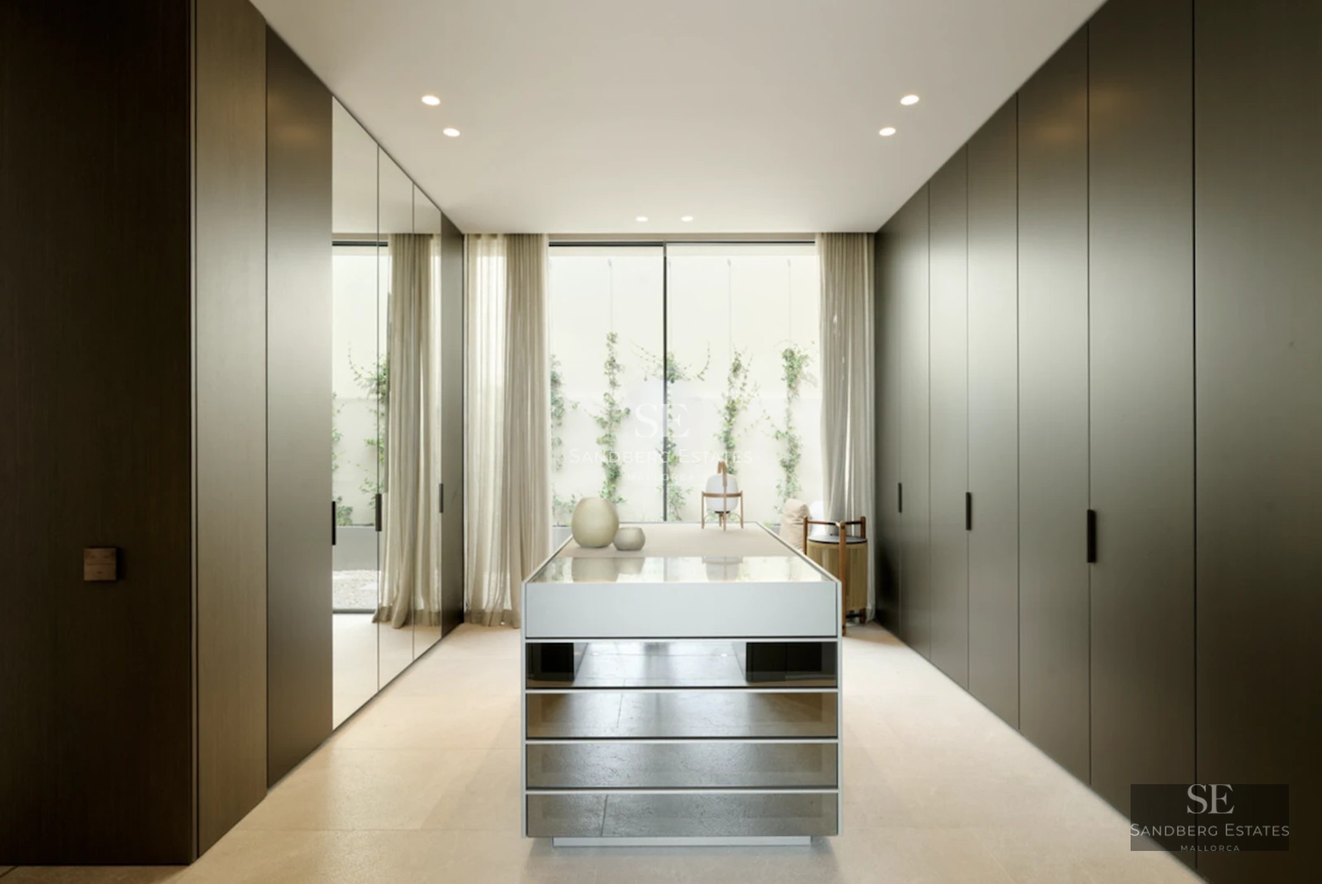 Spacious living room featuring floor-to-ceiling windows, light wood floors, modern fireplace, and designer sofas. Panoramic views.