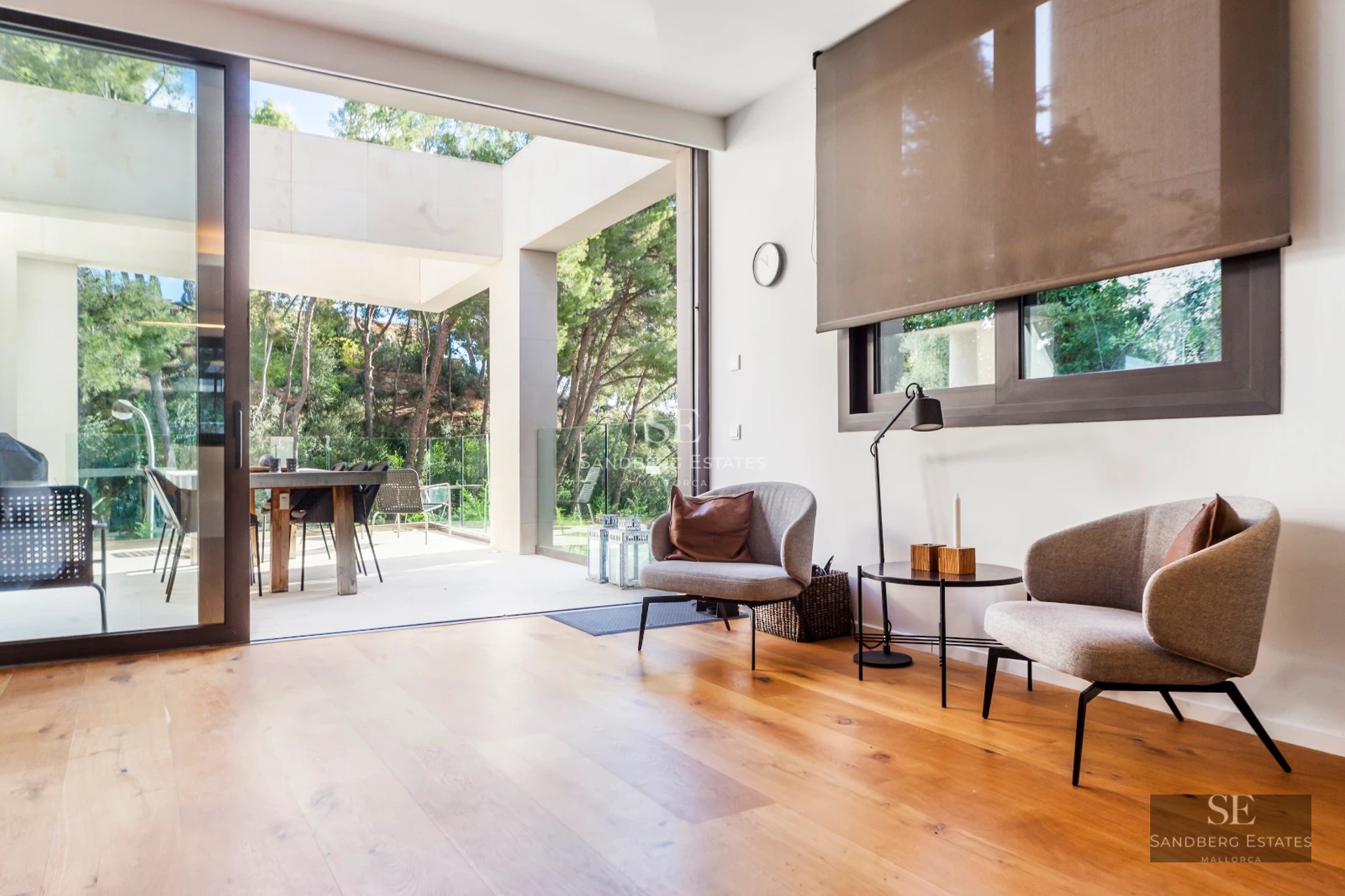 Exterior view of a modern villa featuring an infinity pool, lush garden, and spacious terraces. Contemporary architecture and manicured landscaping.