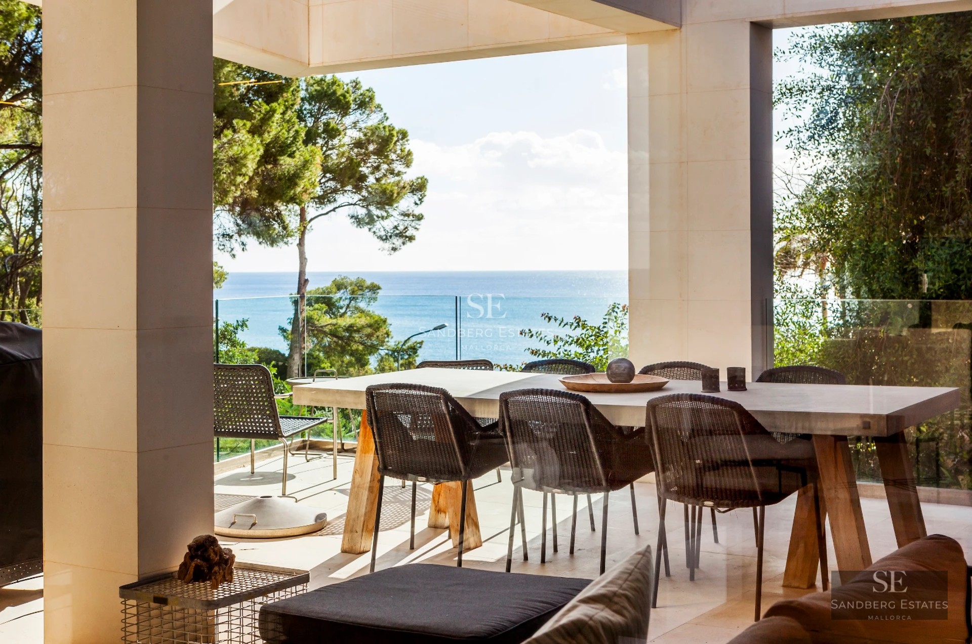 Spacious, bright living room with large windows overlooking a shimmering pool. Modern design with wood floors and elegant furnishings.