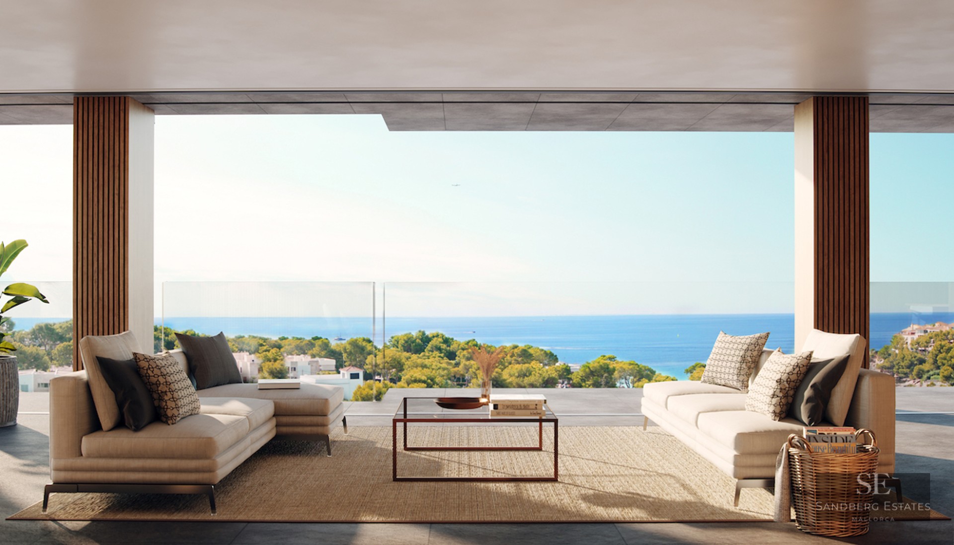 Modern terrace with beige sofas and glass railing overlooking the Mediterranean Sea and lush greenery.