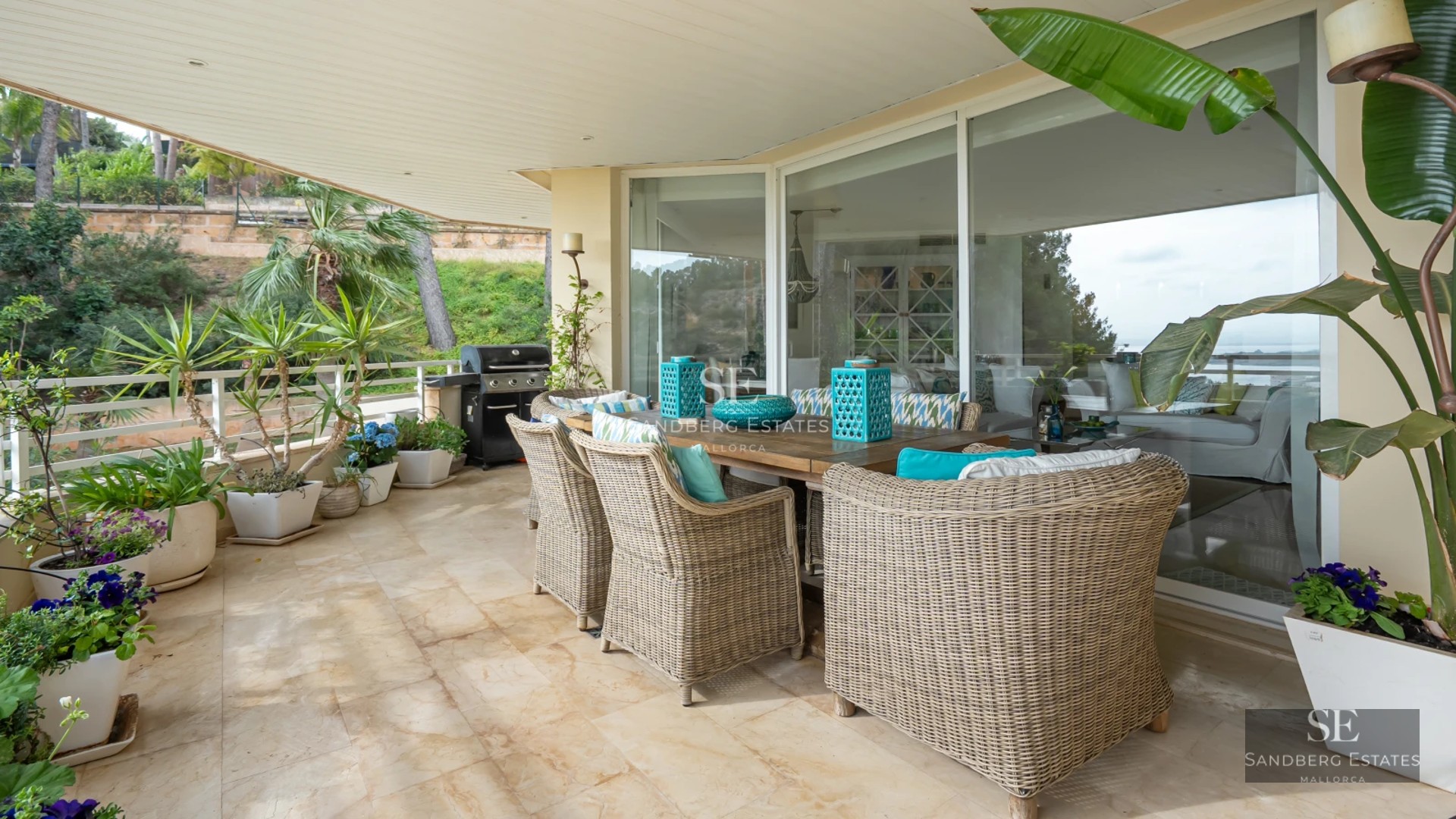Exterior view of a modern villa featuring an infinity pool, wooden deck, and large windows. Lush garden and sleek architectural design.