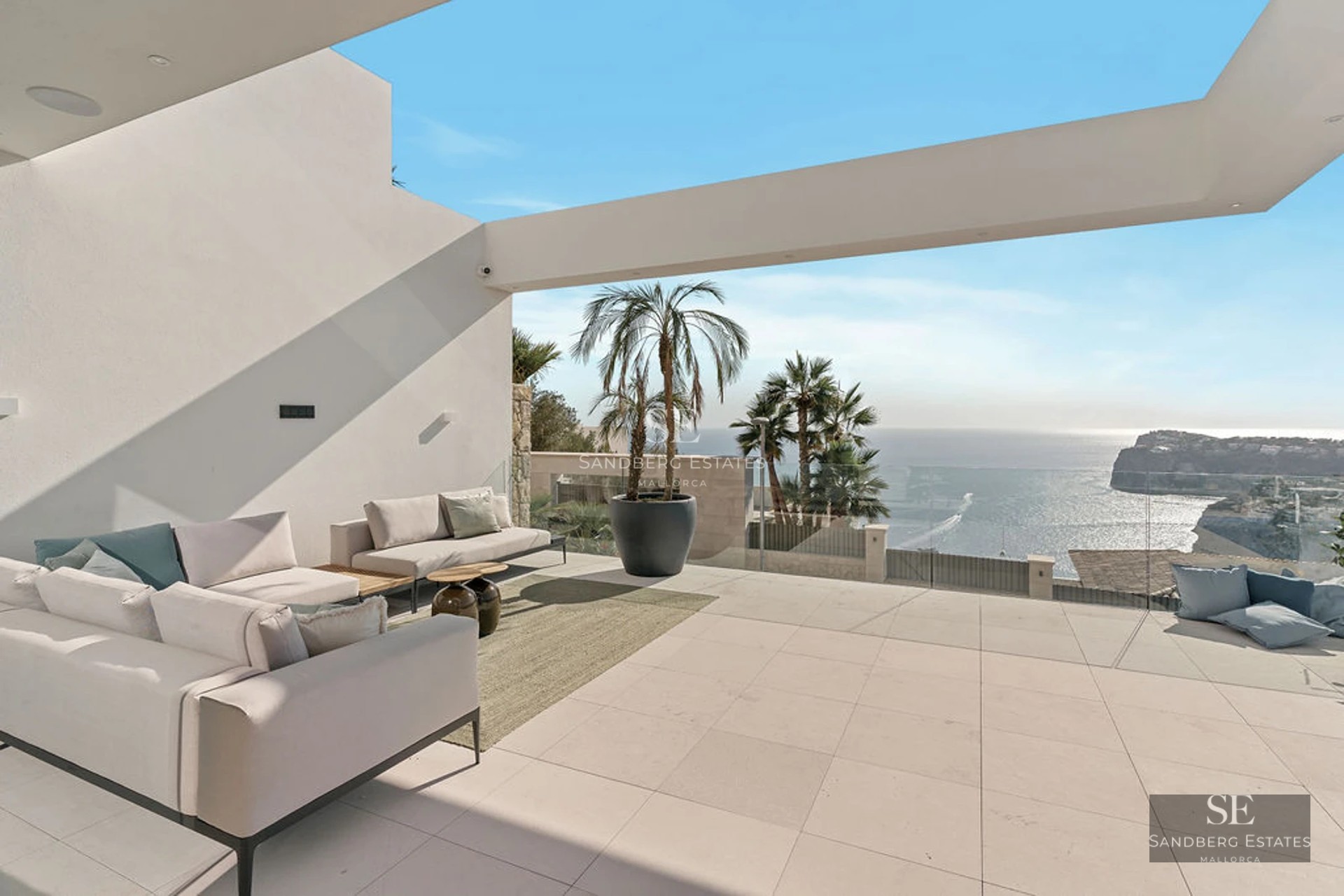 Exterior view of a modern house with pool, manicured garden, and large windows reflecting sunlight.