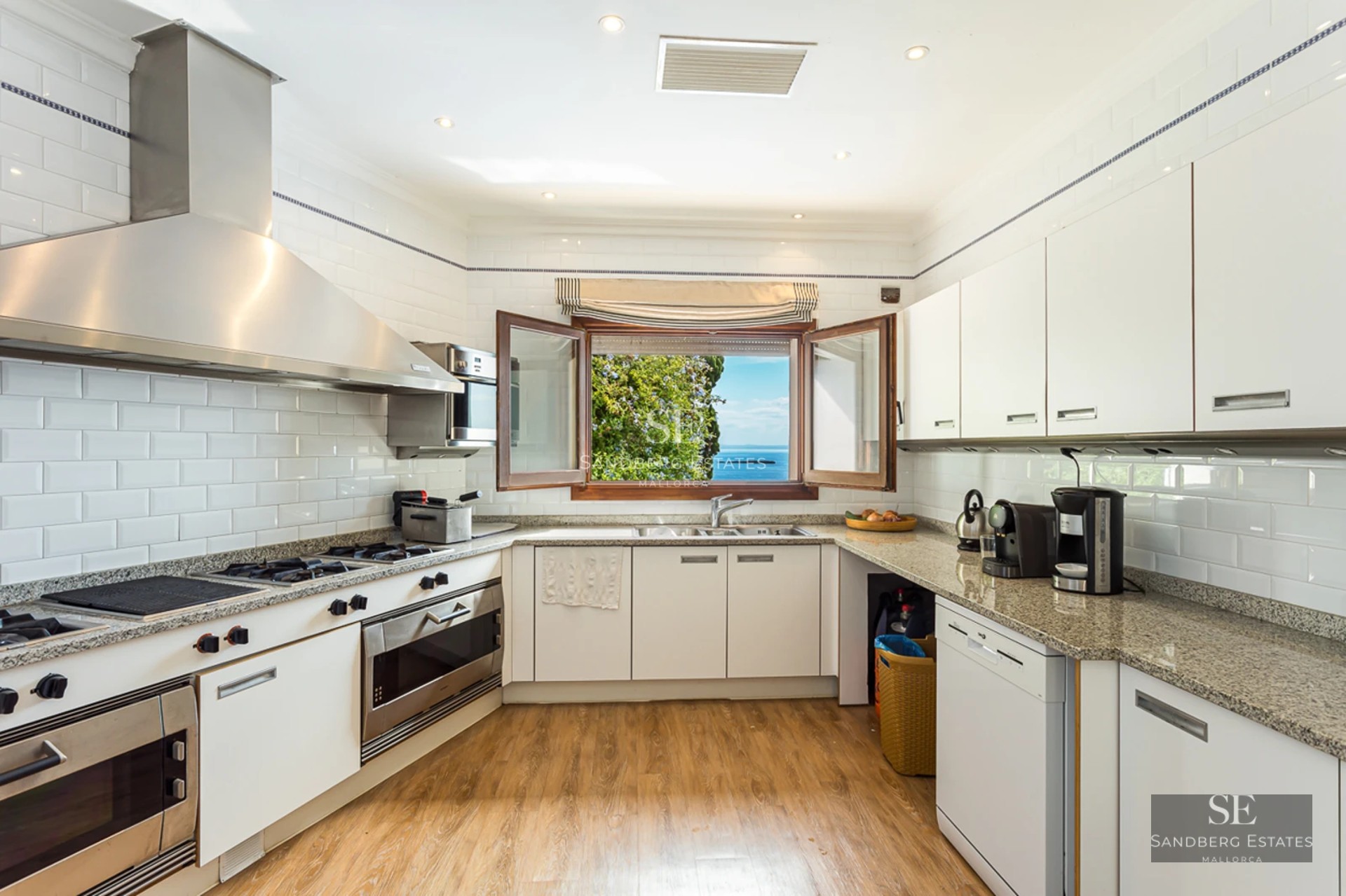 Extérieur d'une villa moderne avec piscine à débordement, grandes terrasses, design minimaliste et vues panoramiques. Façade blanche et végétation luxuriante.