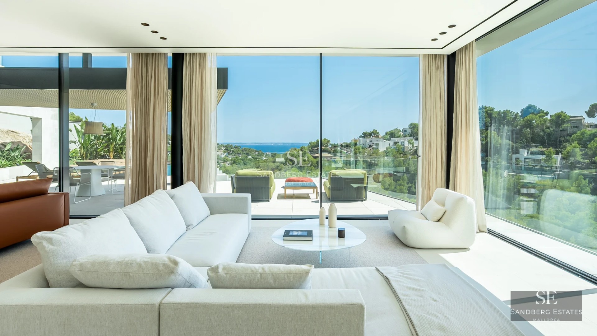 View of a modern villa with pool, large windows, covered terrace and elegant outdoor furniture. Lush garden.