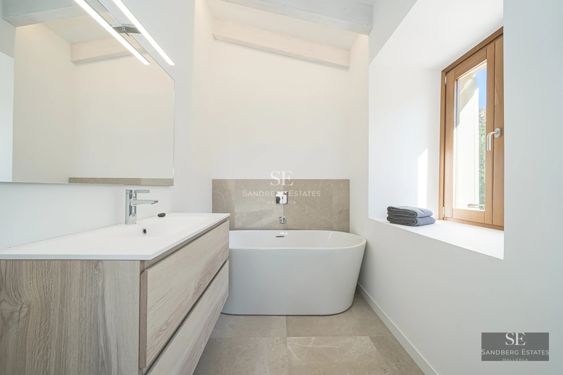 Spacious, bright living room with large windows, modern sofas, designer rug, and panoramic sea views.