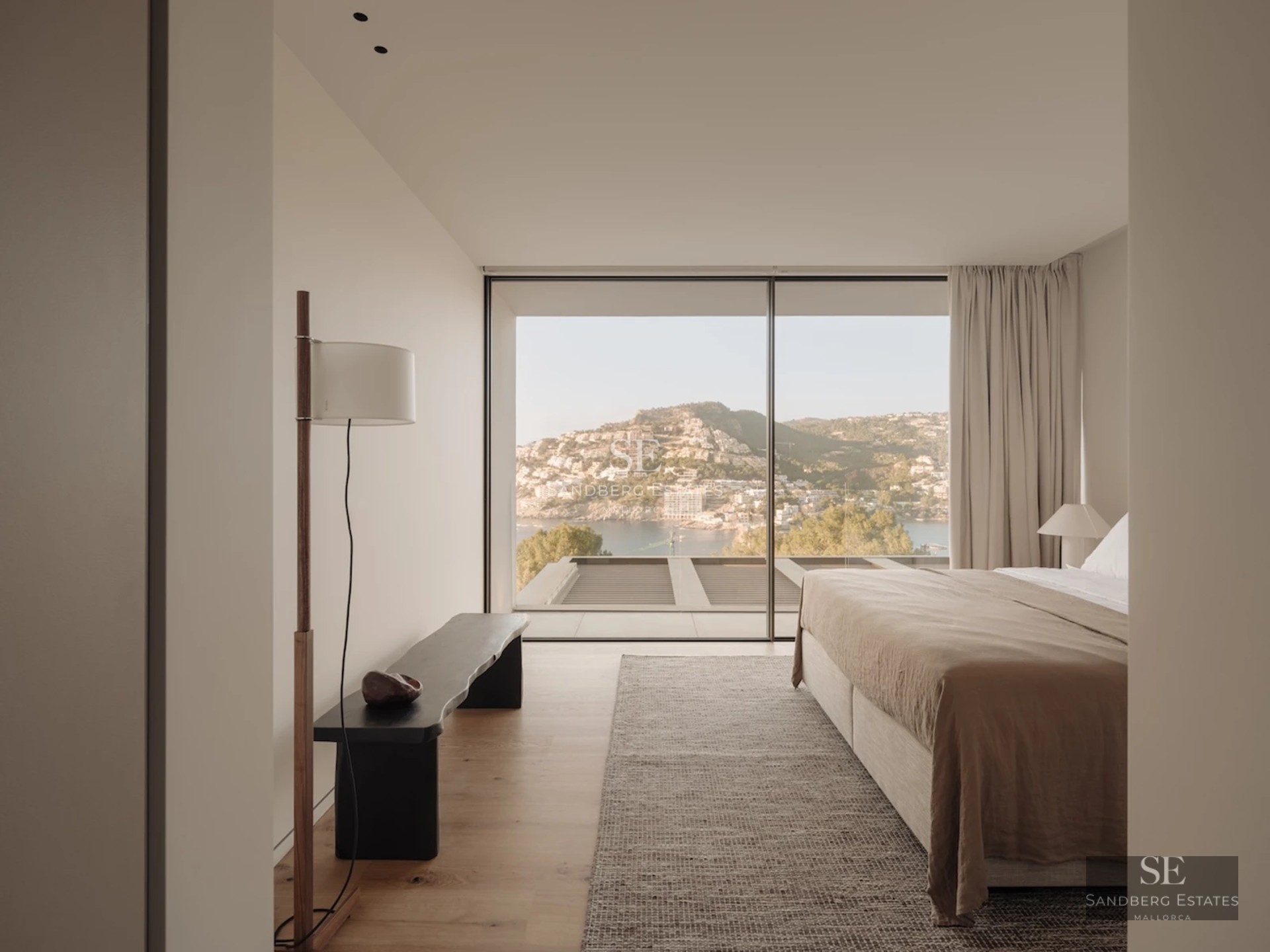 Spacious living room with panoramic windows, modern fireplace, and minimalist decor. Natural light highlights wood and stone textures.