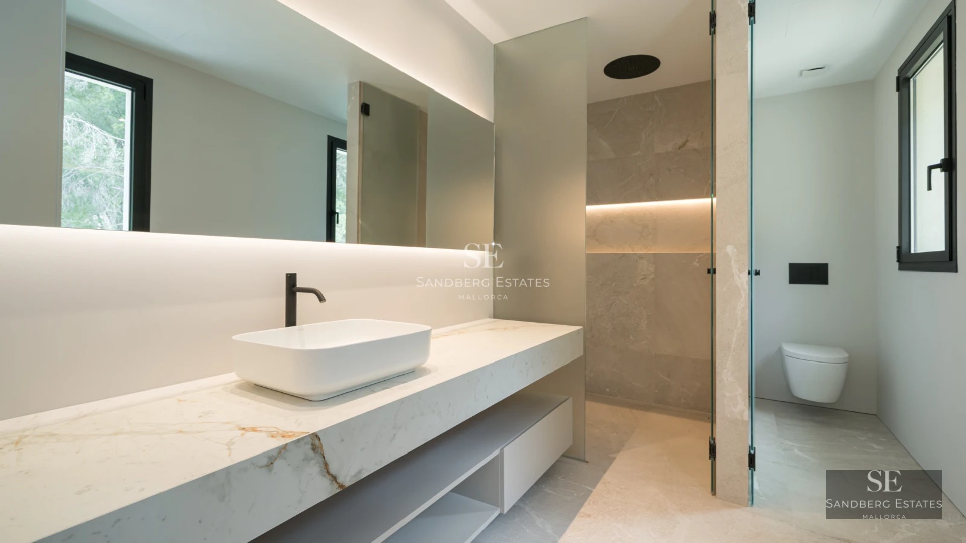 Image of an elegant pool with sun loungers and umbrellas, surrounded by gardens and with a modern building in the background.